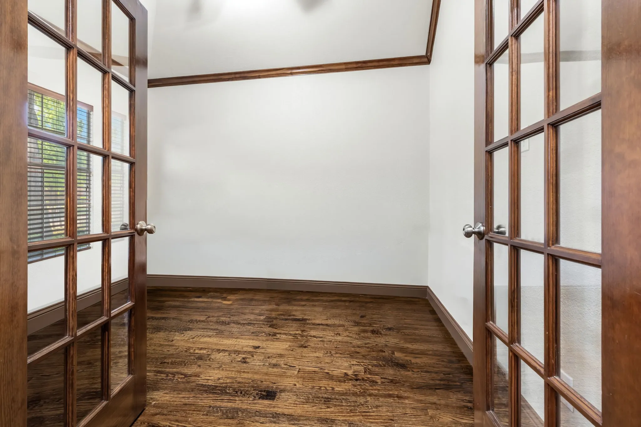 Beautiful office with rich hardwood floors and French Doors for privacy.