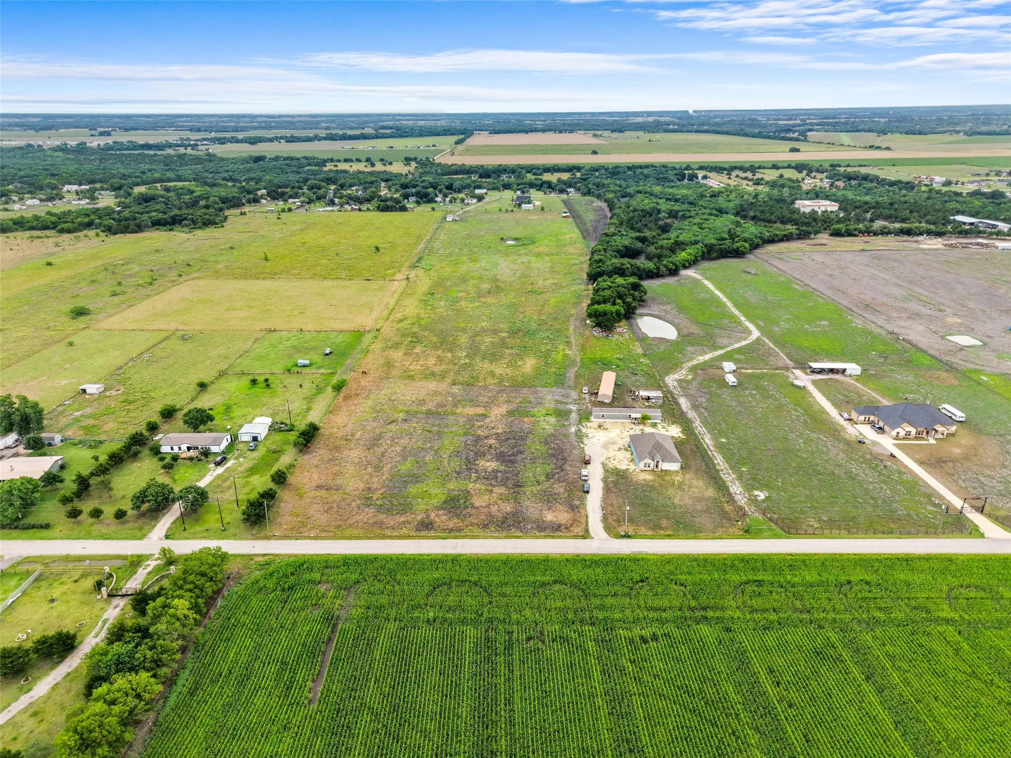 Expansive rural landscape featuring a variety of land uses including agricultural fields, open pastures, and wooded areas