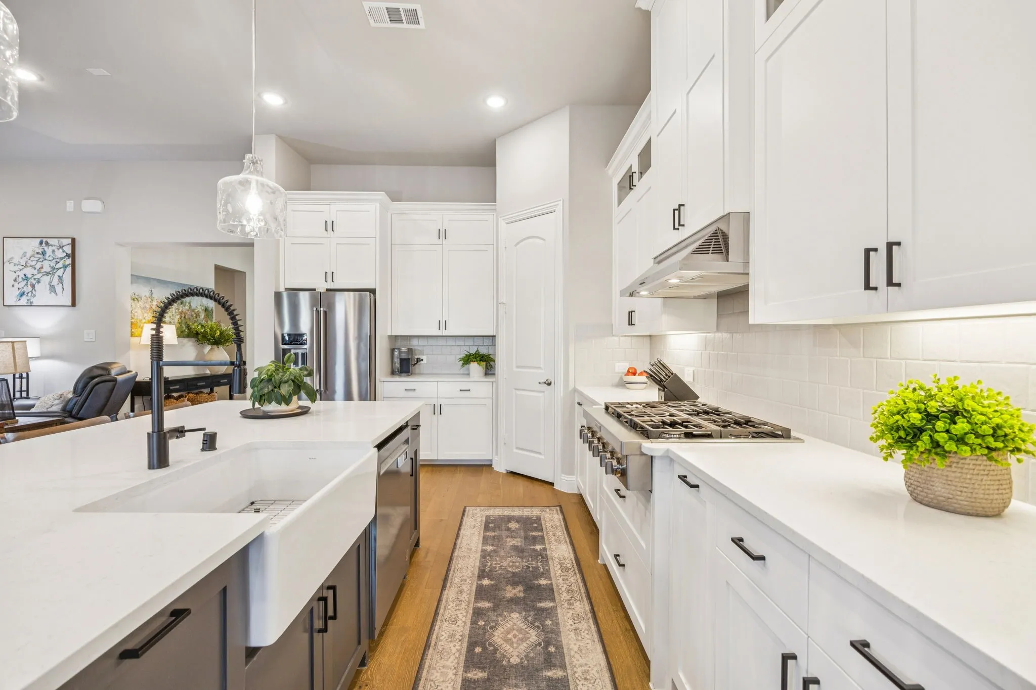 Farmhouse Sink And Upgraded Faucet Anchor The Kitchen, With An Elongated Quartz Eat-In Buffet