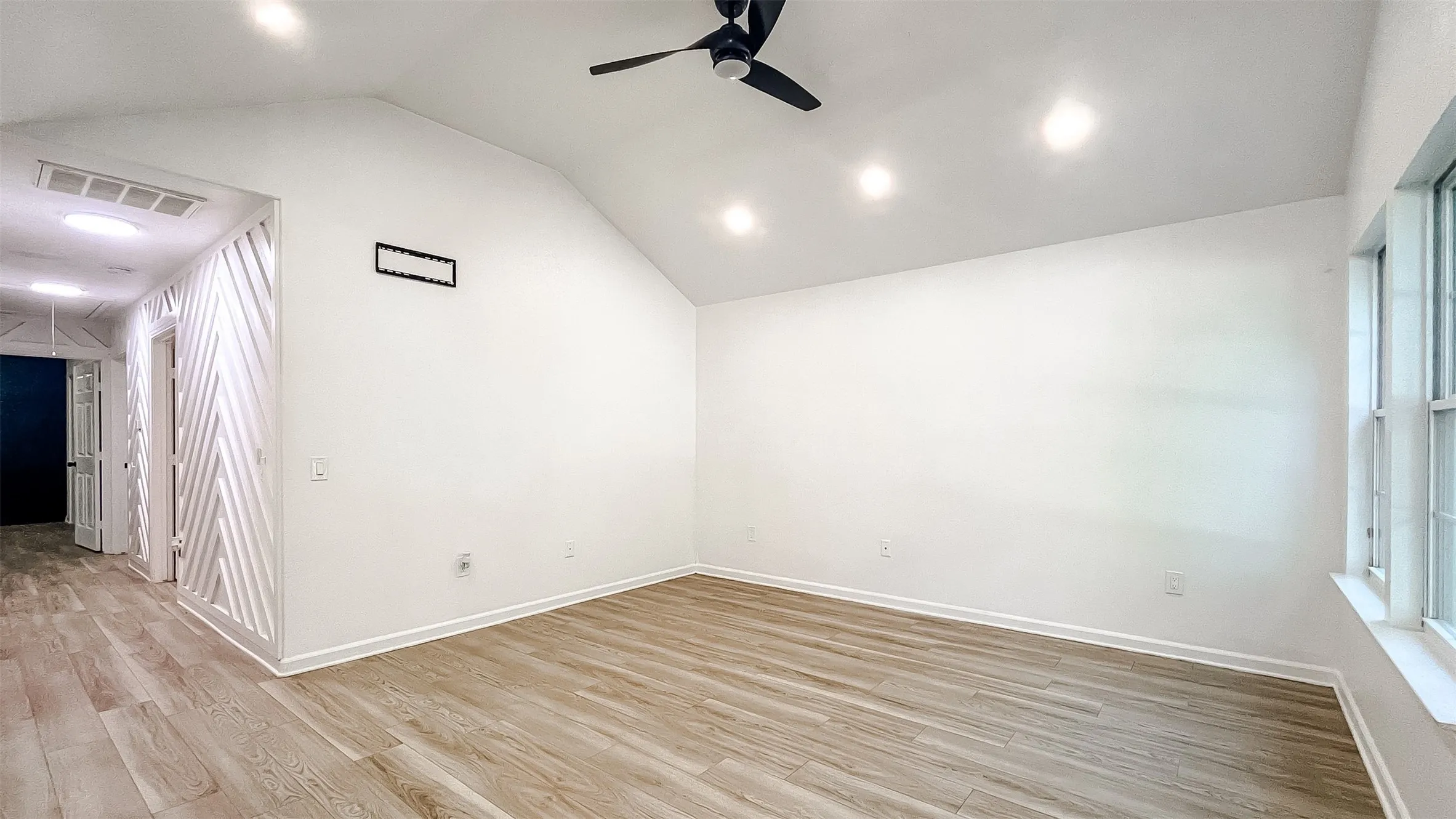 Versatile room with ceiling fan and wood-look floors, perfect for a bedroom, home office, or hobby space.