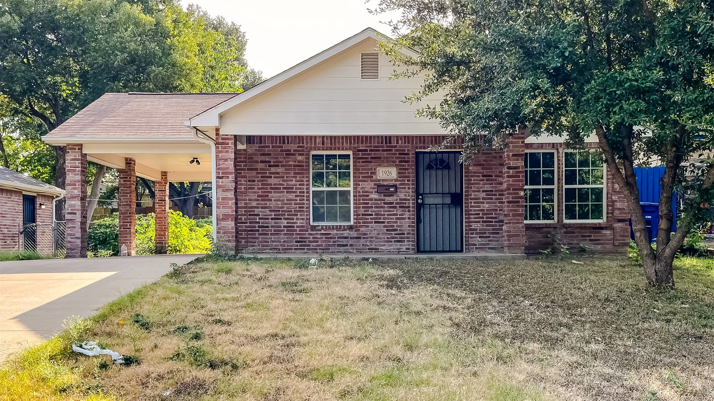 Traditional brick construction surrounded by mature trees and plenty of open lawn space.