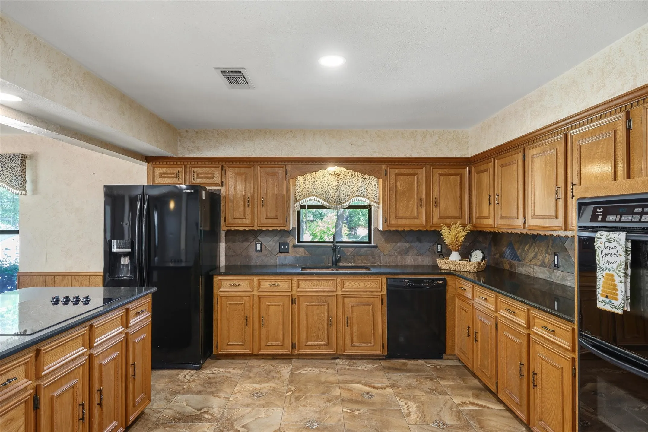 Kitchen window looks out to acreage -- the beautiful park-like setting with hardwood tree canopy. Refrigerator conveys with sale.