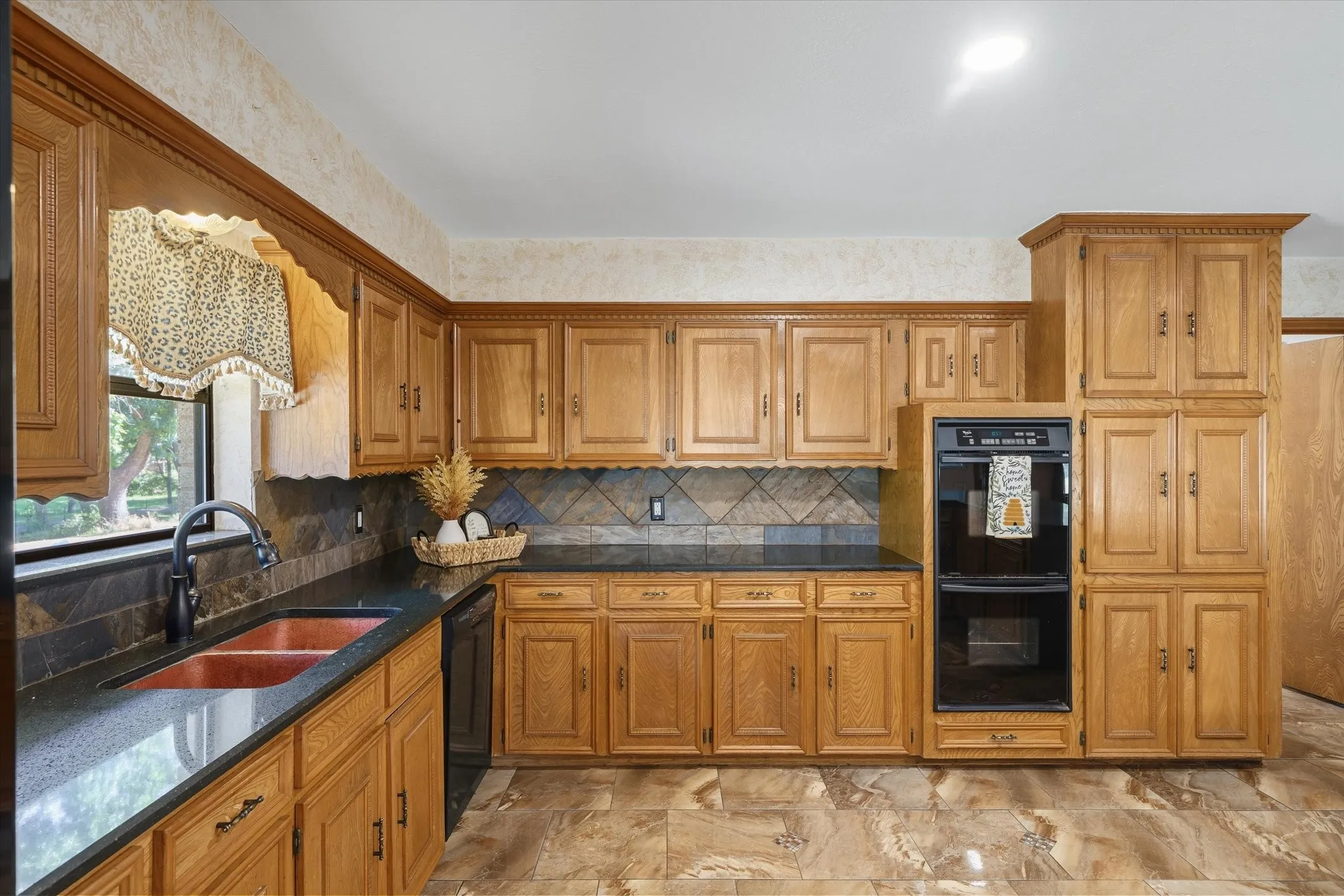 Beautiful cabinetry and plenty of storage for all your kitchen items -- double oven, granite countertops and tile backsplash