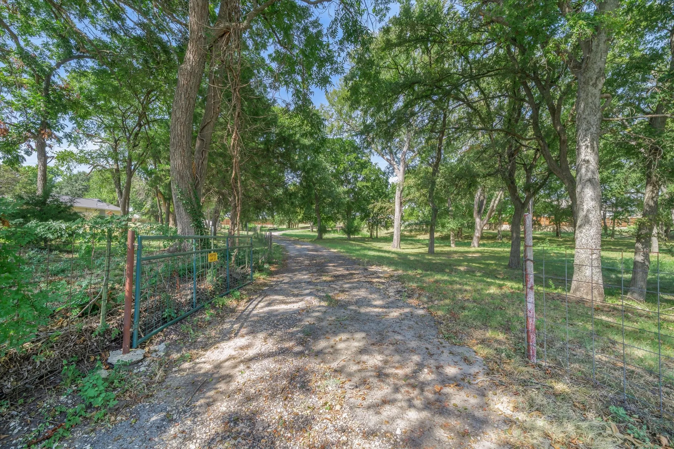 A second gate from the road to the acreage side of the property with a drive that leads up to the large, 60 X 60 shop -- a park-like setting for your business or possibly a future build site