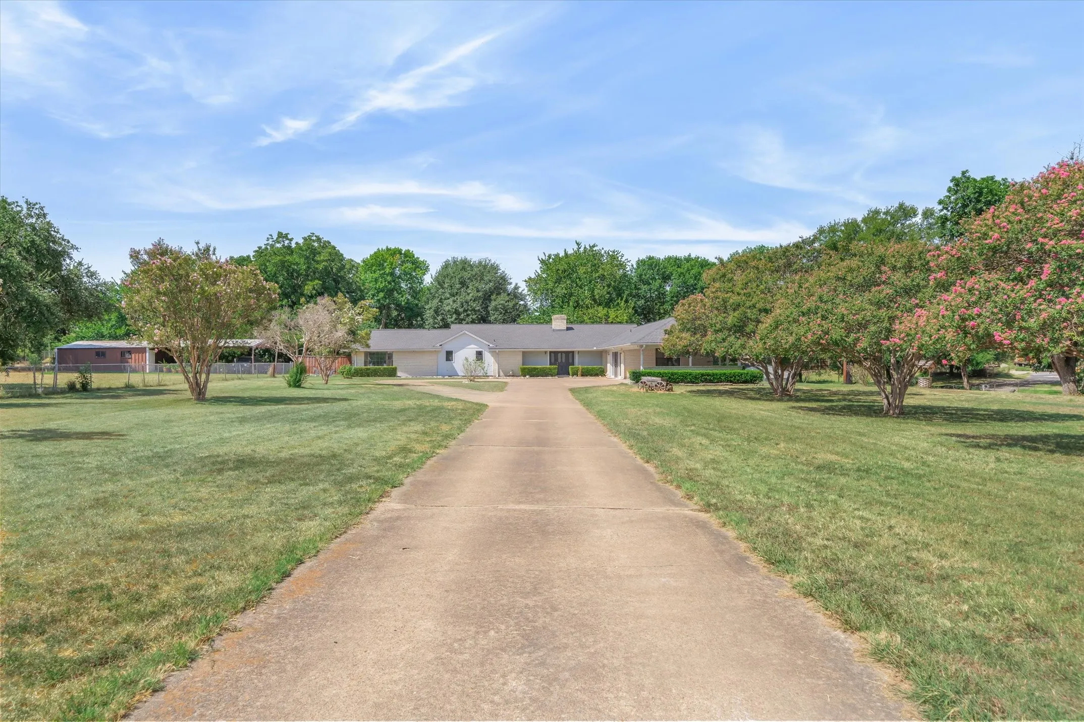 The long driveway leads to a circle drive at the front entry to this large home.