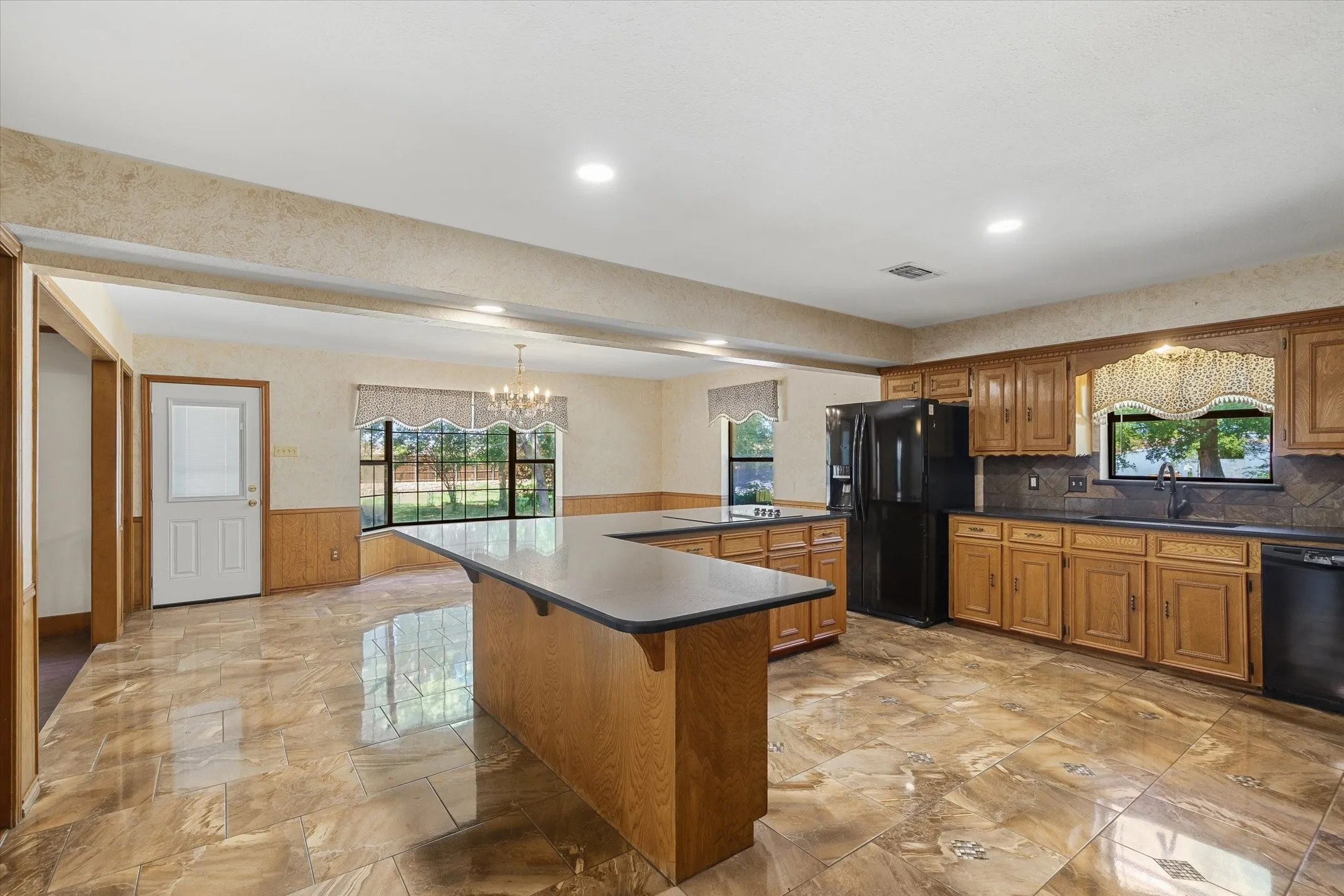 Large kitchen and dining area with door that goes out to the covered patio