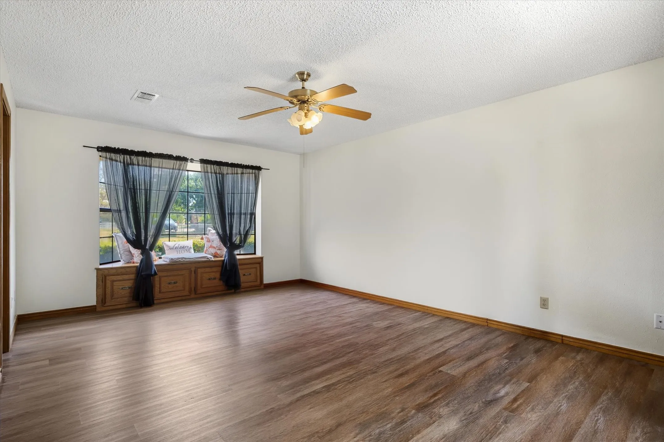 The large primary bedroom features a window seat wide enough to make your favorite place to read and relax.