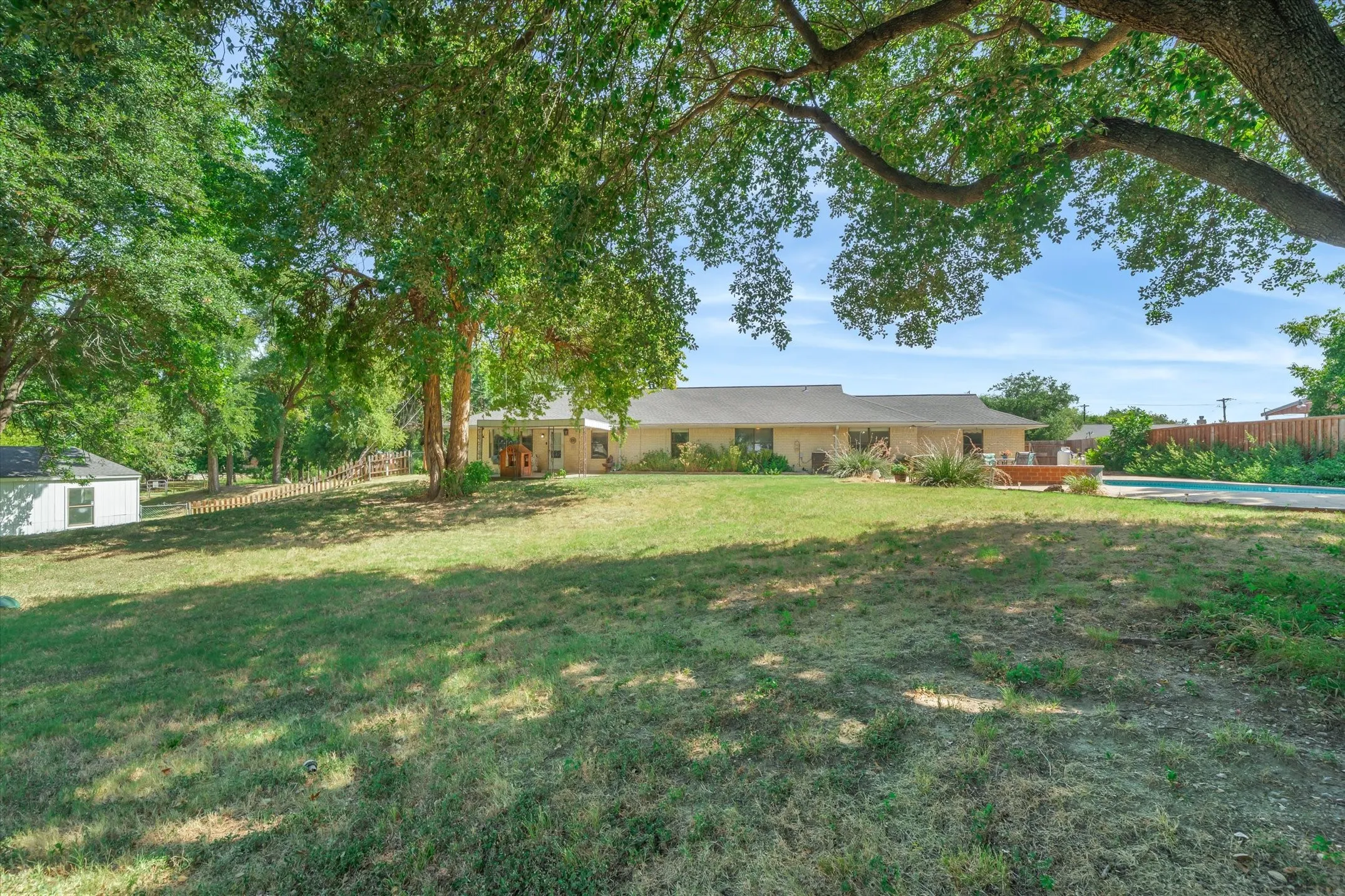 Back view of the house, backyard, and pool area
