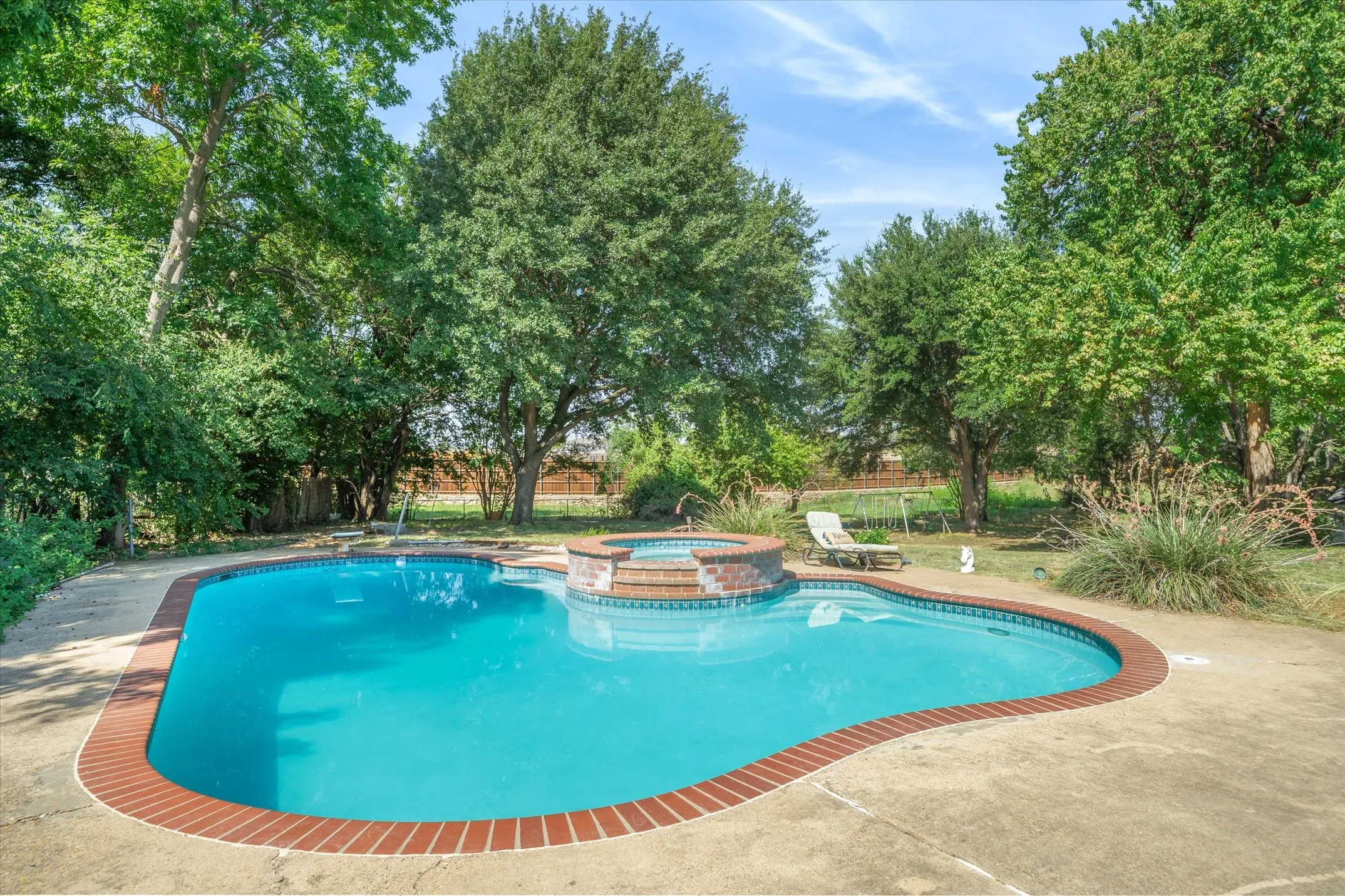 Cool, beautiful, and private with a lovely backdrop of hardwoods and perennial landscaping!