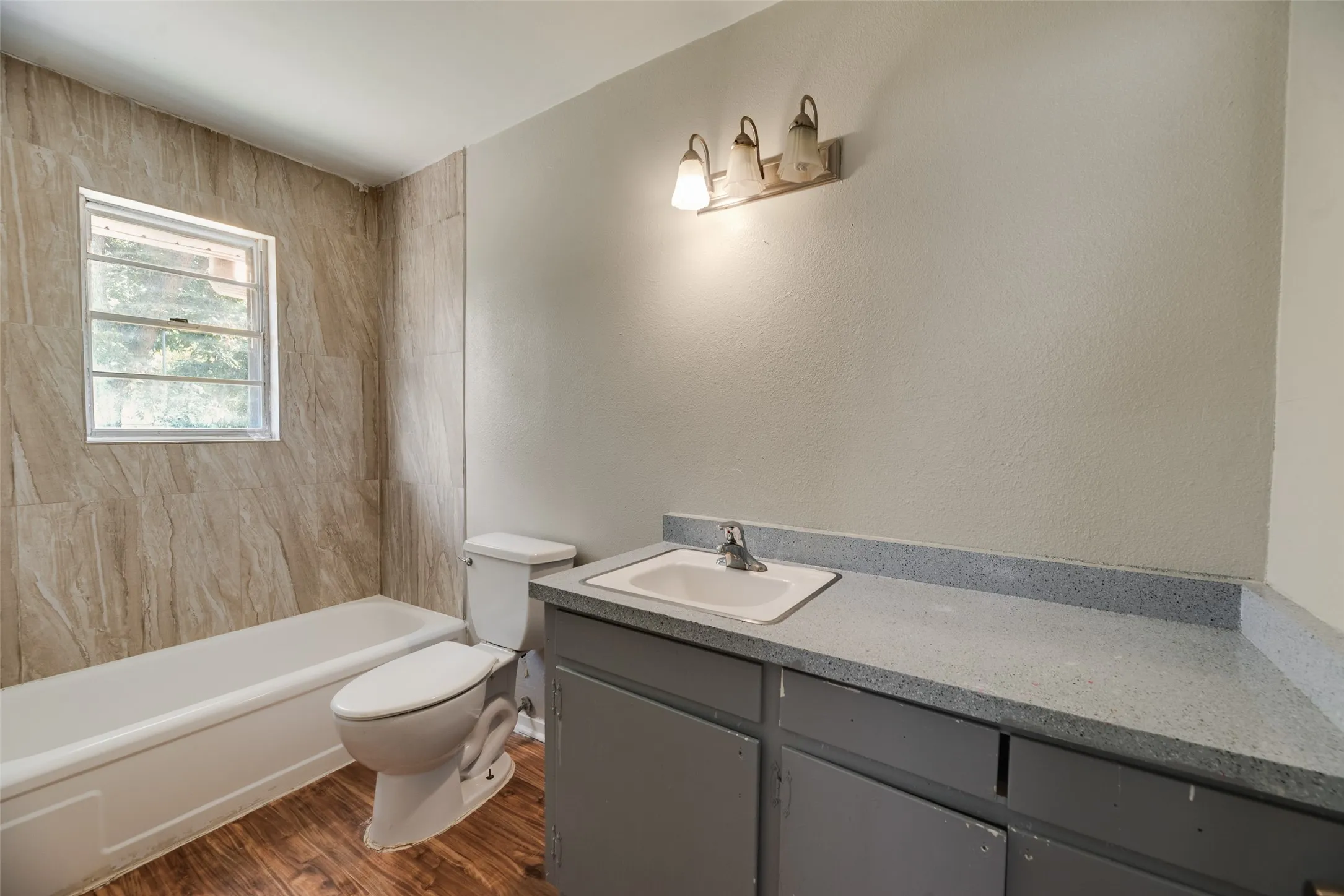 Built-in vanity with a single basin sink and gray base cabinetry