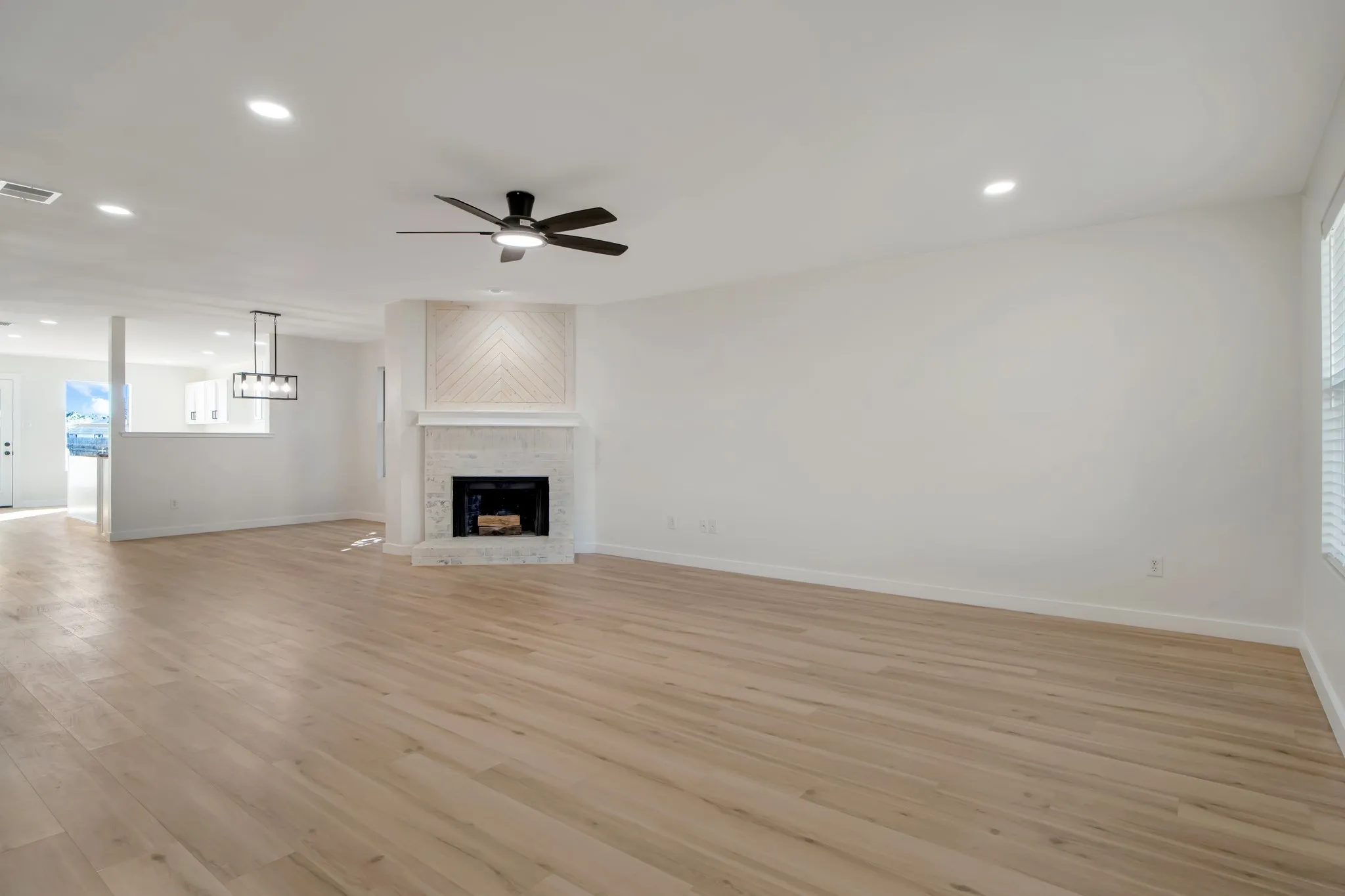 Recessed lighting, ceiling fan, wood-finish flooring, white walls, and window with blinds