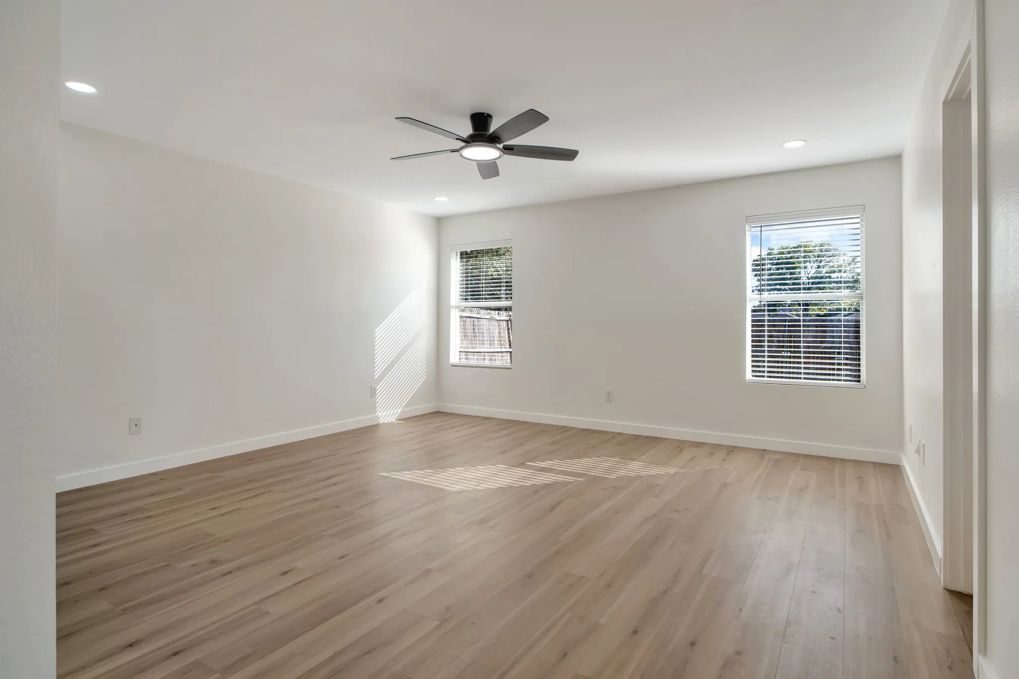 Recessed lighting, ceiling fan, wood-finish flooring, white walls, and window with blinds