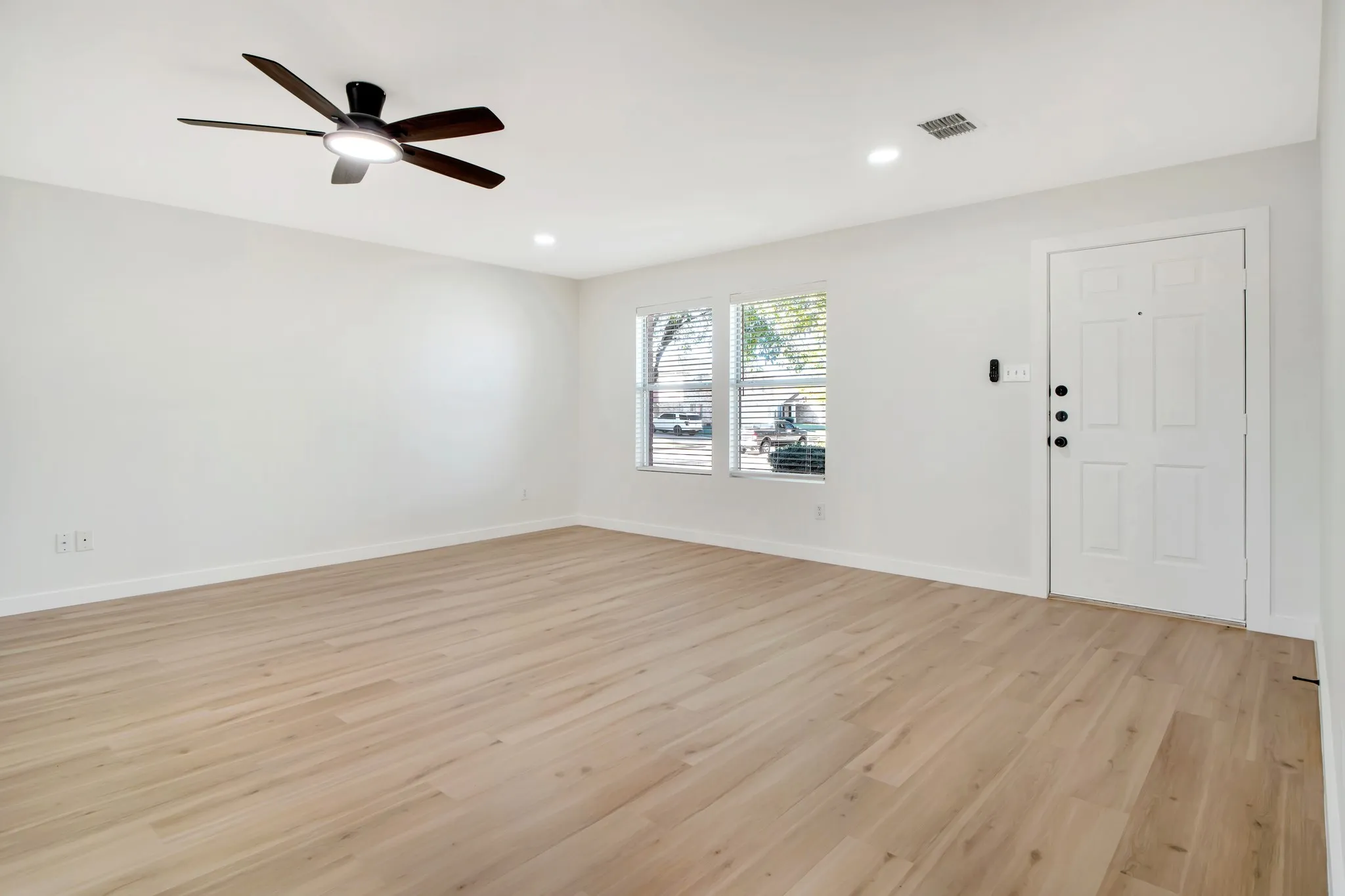 Light wood-finish flooring with white walls