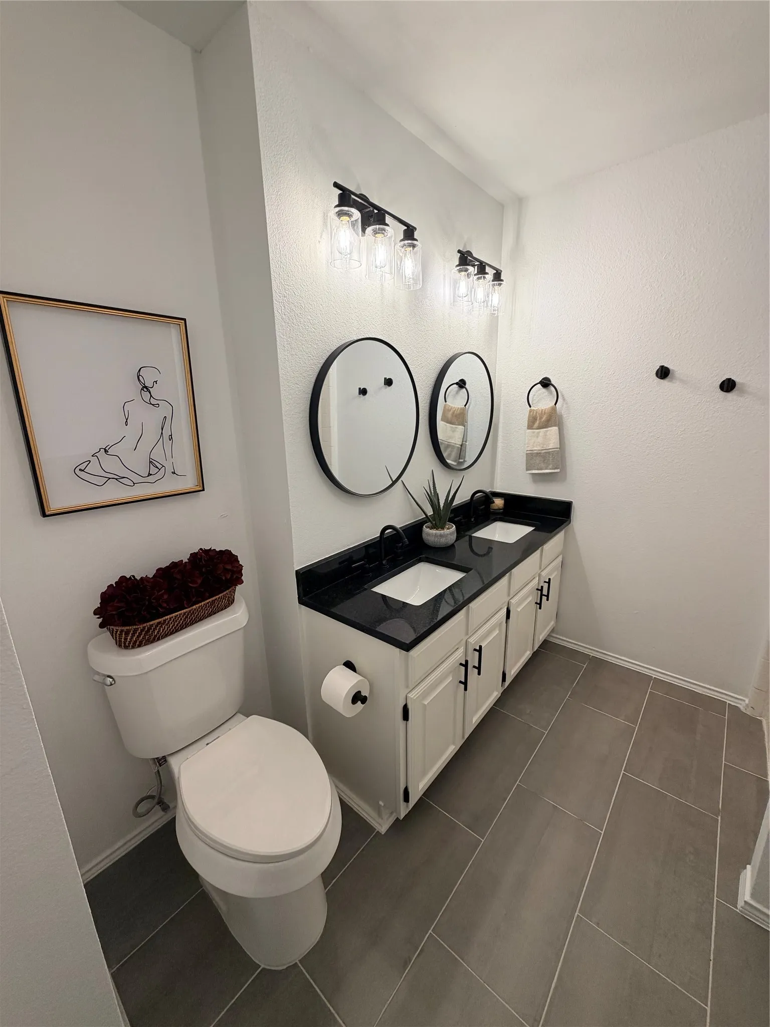 Dual vanity with black countertops and integrated sinks