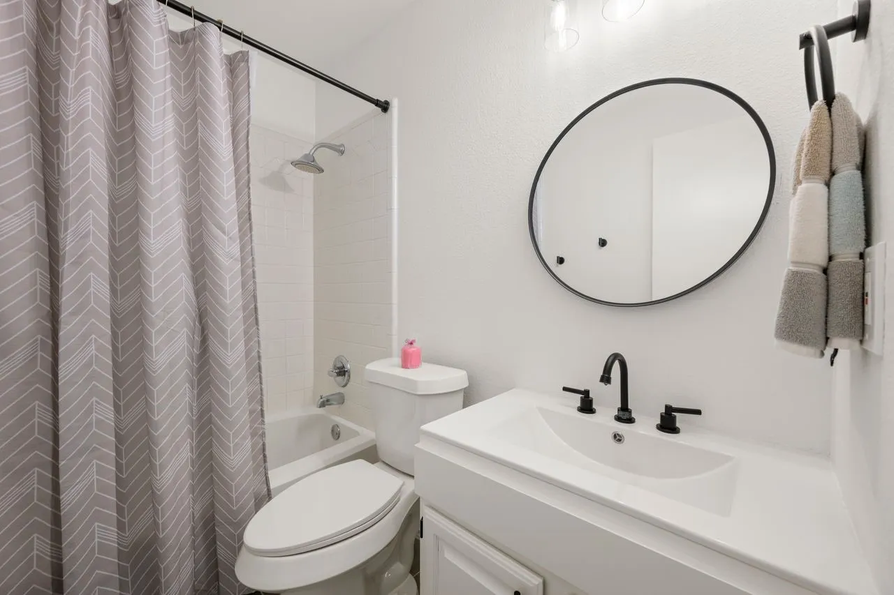 White subway tile shower surround with a chrome showerhead and tub filler