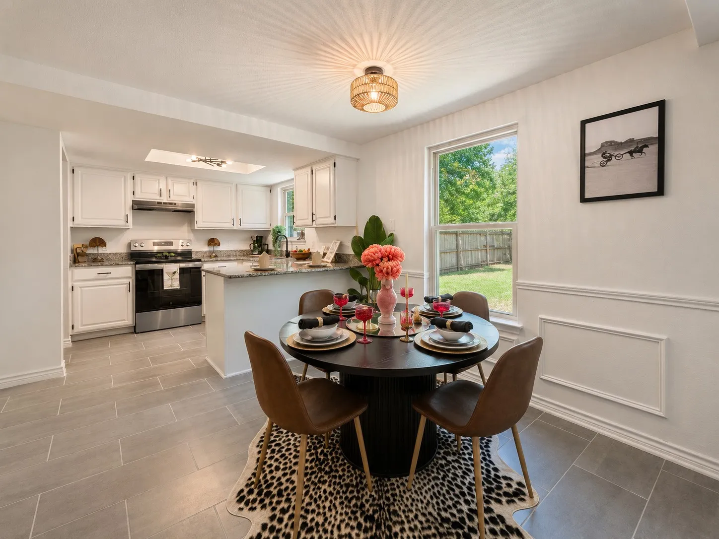Kitchen with white cabinetry, stainless steel appliances, granite countertops, and light gray tile flooring