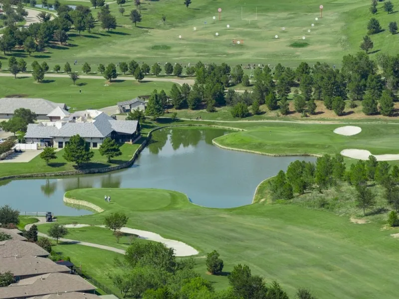 Expansive golf course setting featuring a water hazard, sand traps, and manicured greens