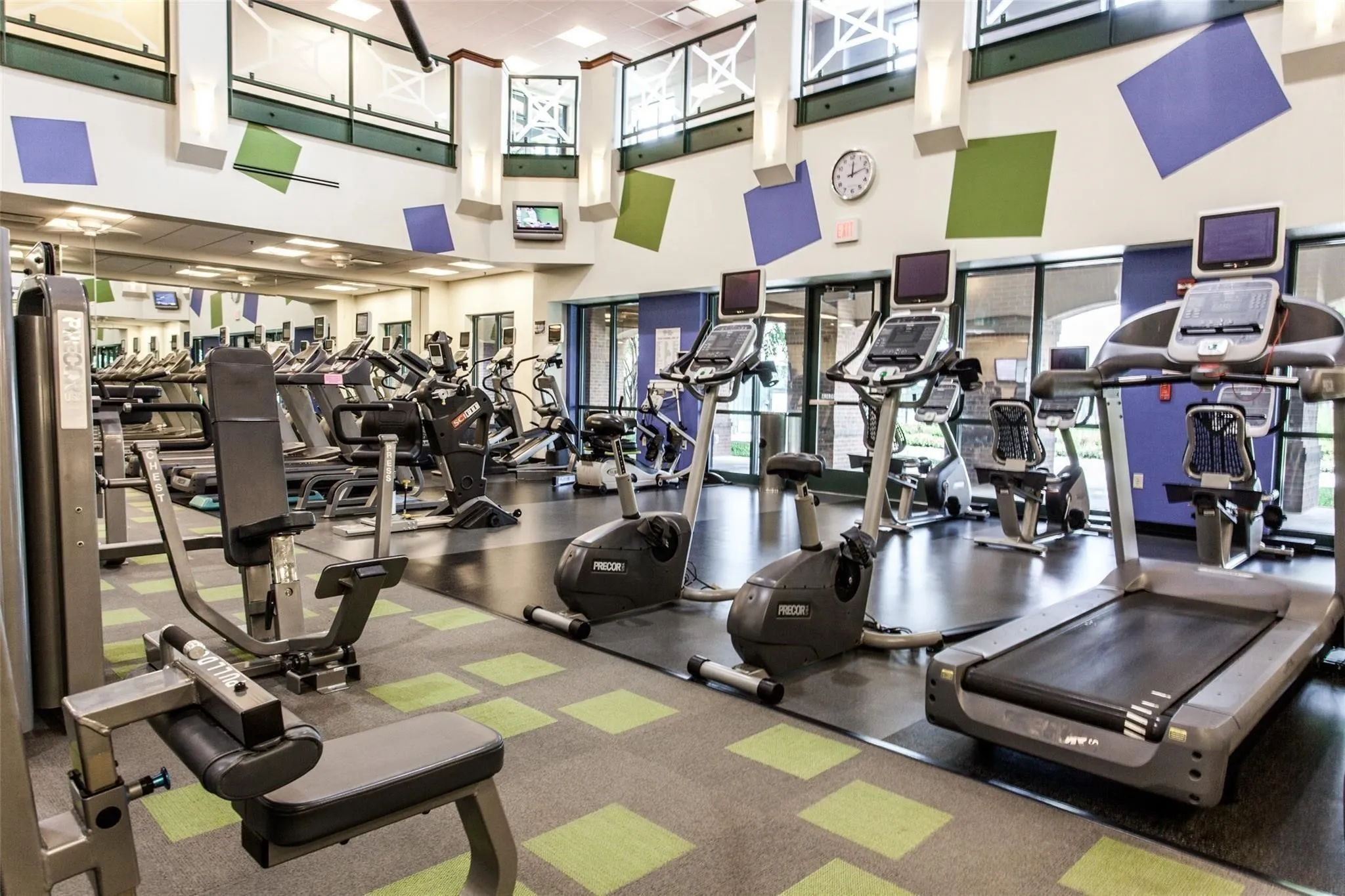 Fitness center featuring large floor-to-ceiling windows, mirrored wall, and recessed ceiling lighting