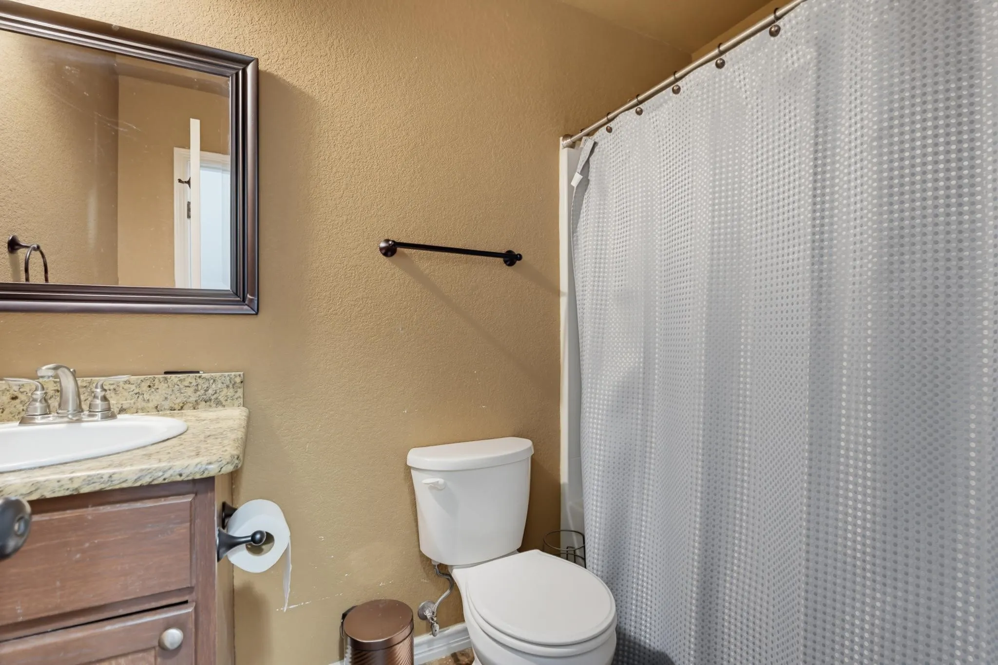 Vanity with stone-finish countertop, undermount sink, framed mirror, and built-in cabinetry