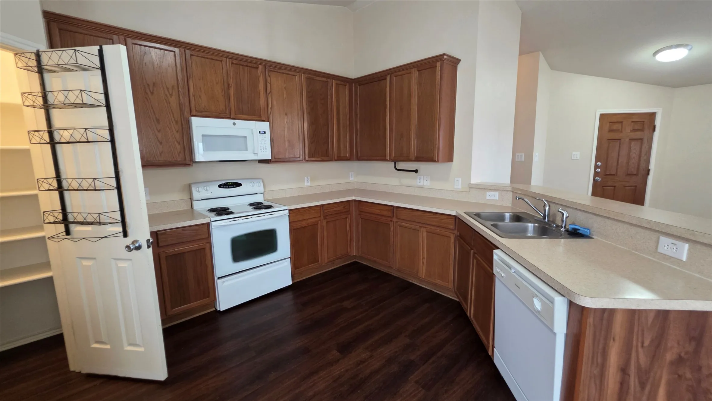Spacious pantry with built-in rack! Kitchen sink and dishwasher conveniently behind peninsula to keep the kitchen looking tidy to your guests!
