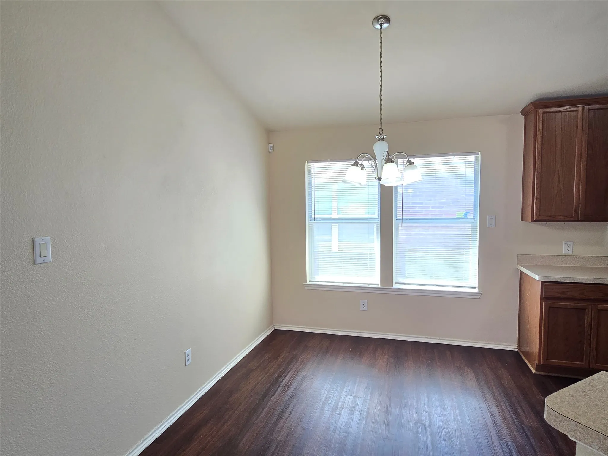 Dining space near kitchen with large windows to let in natural light.