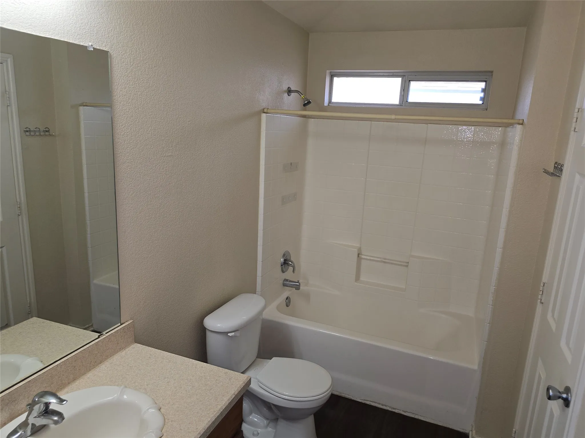 Space for your own favorite rack above the toilet. Private combination bathtub and shower in the primary bathroom.