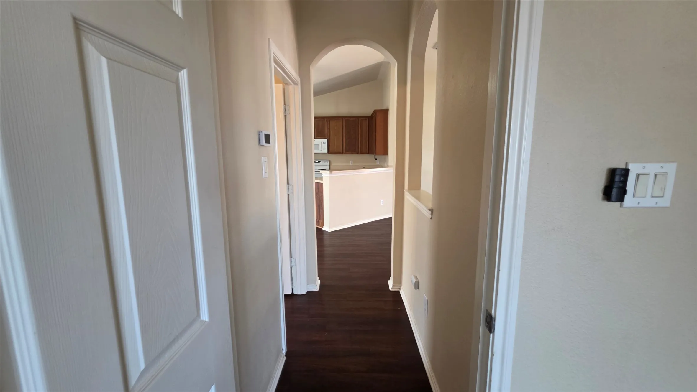 Archways in the primary hallway. Primary bedroom's ceiling fan is remote-controlled.