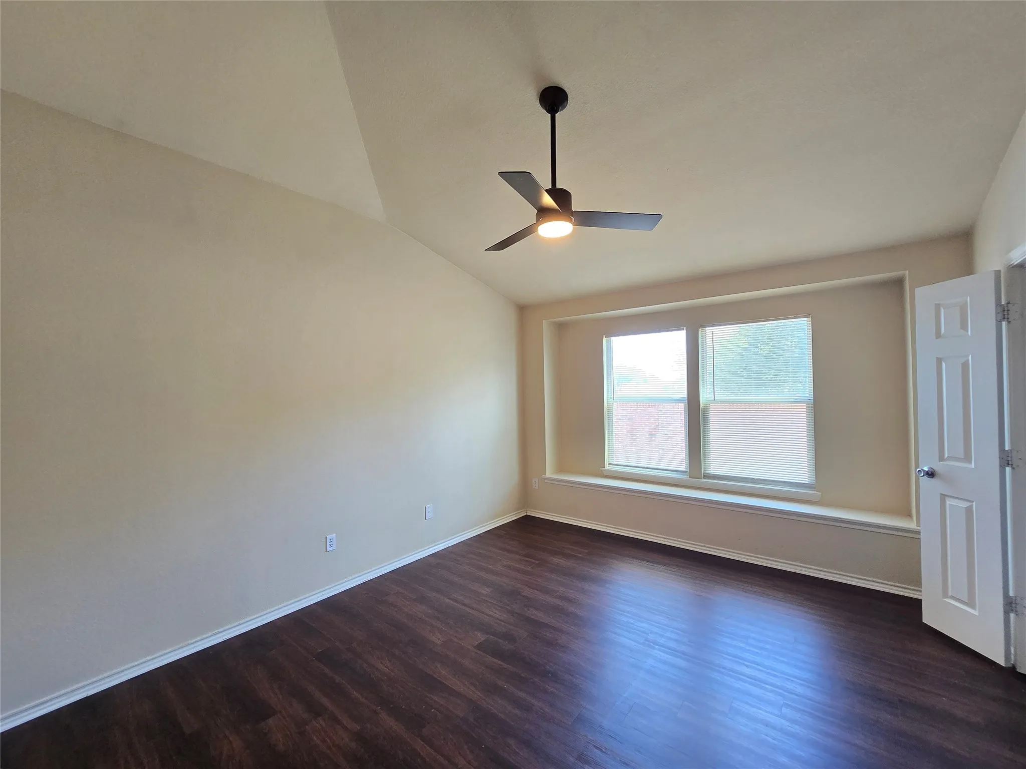 Primary bedroom looks out to backyard through two large windows--with built-in space for decor.