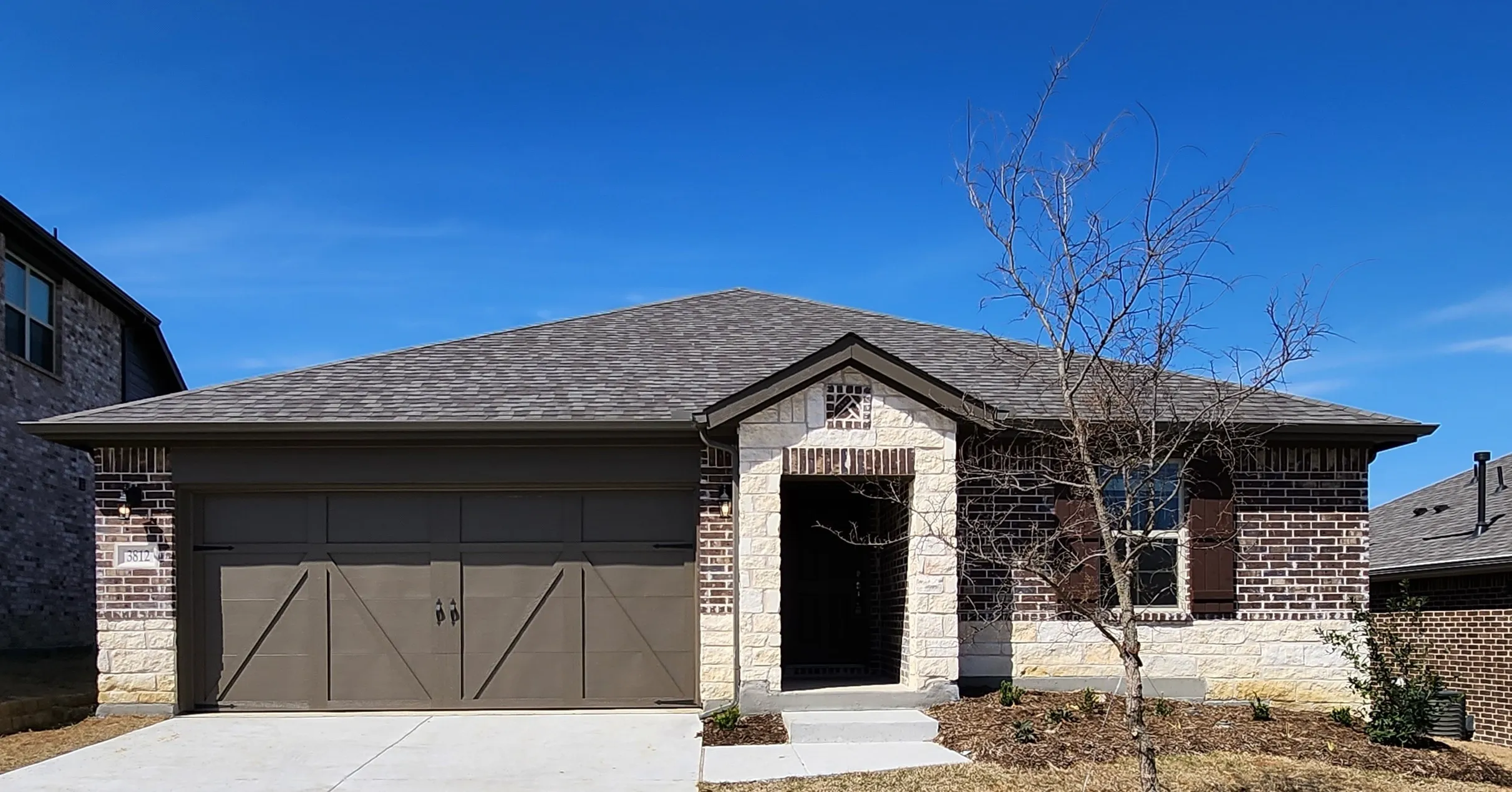 Stone and brick exterior with a pitched shingle roof