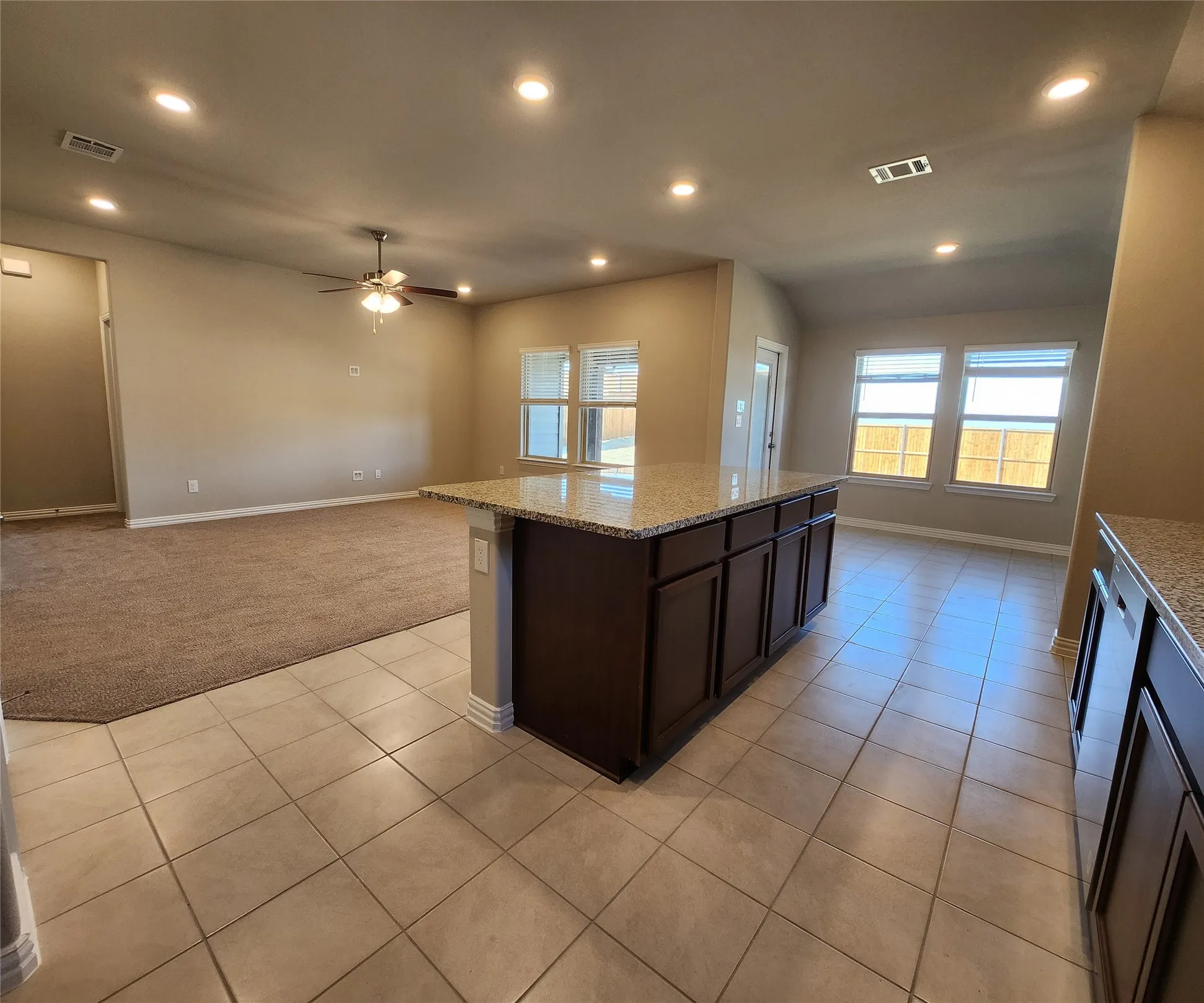 Open-concept living space with recessed lighting, a ceiling fan, and multiple windows
