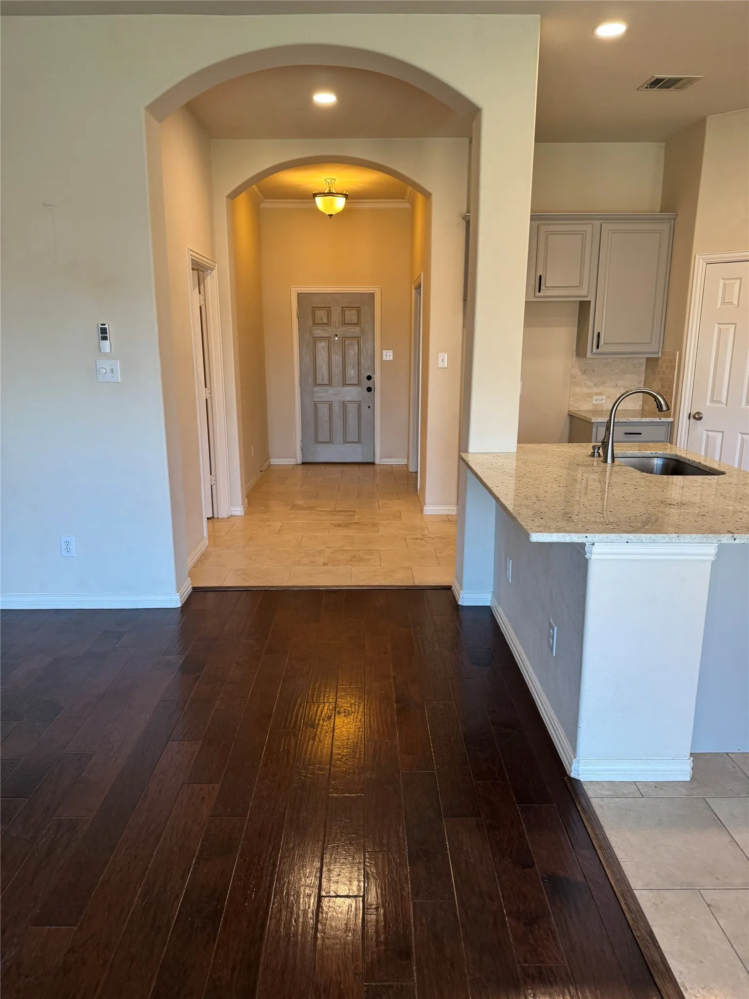 Hallway featuring hardwood / wood-style floors, a sink, baseboards, and recessed lighting