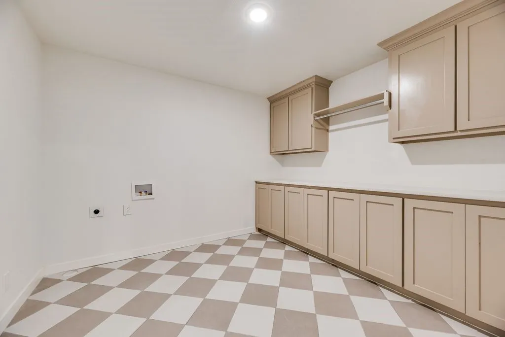 Spacious laundry room with built ins and updated tile. Plenty of room for full size washer and dryer.