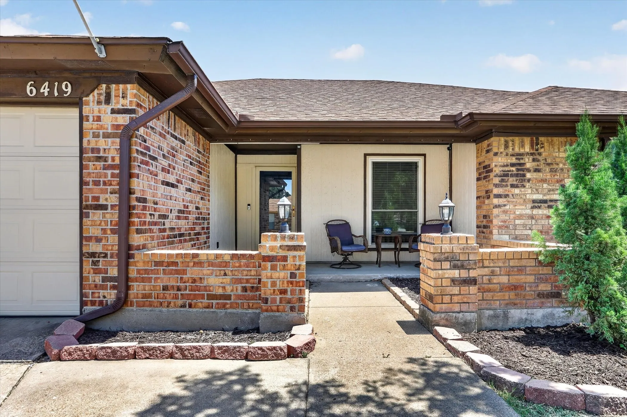 Brick exterior with a covered entryway and attached garage