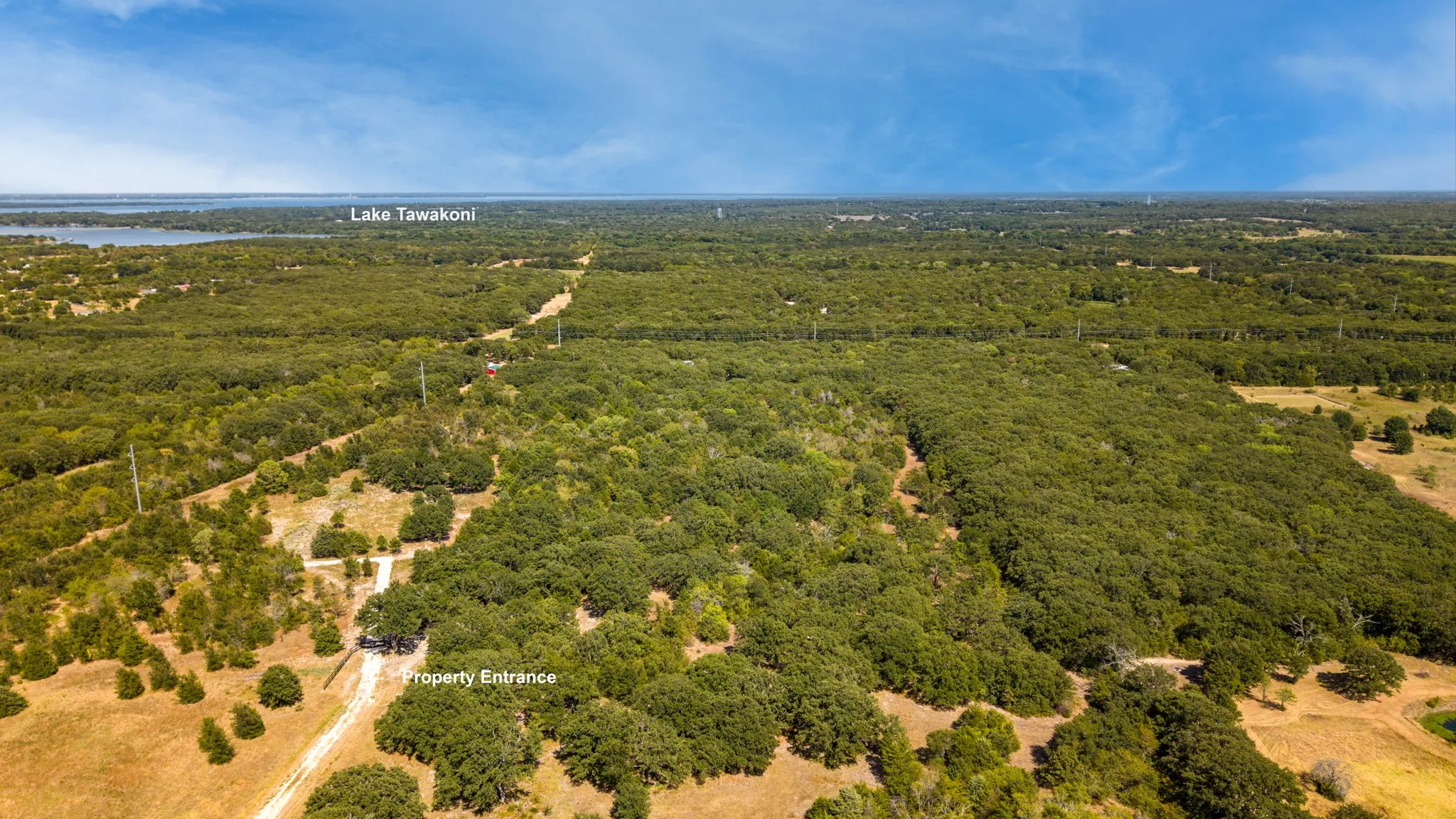 Expansive acreage featuring mature trees, a clear property entrance, and visible access to Lake Tawakoni