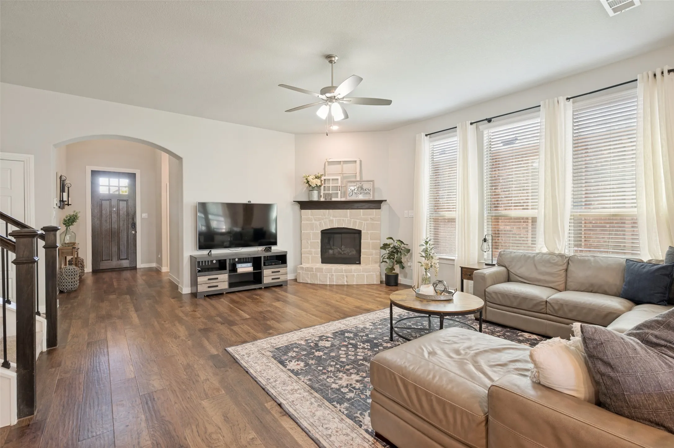 The living room features a cozy stone-surround fireplace.