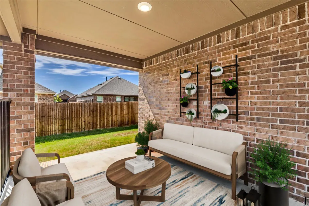 Large covered patio overlooks backyard, virtually staged to show the potential