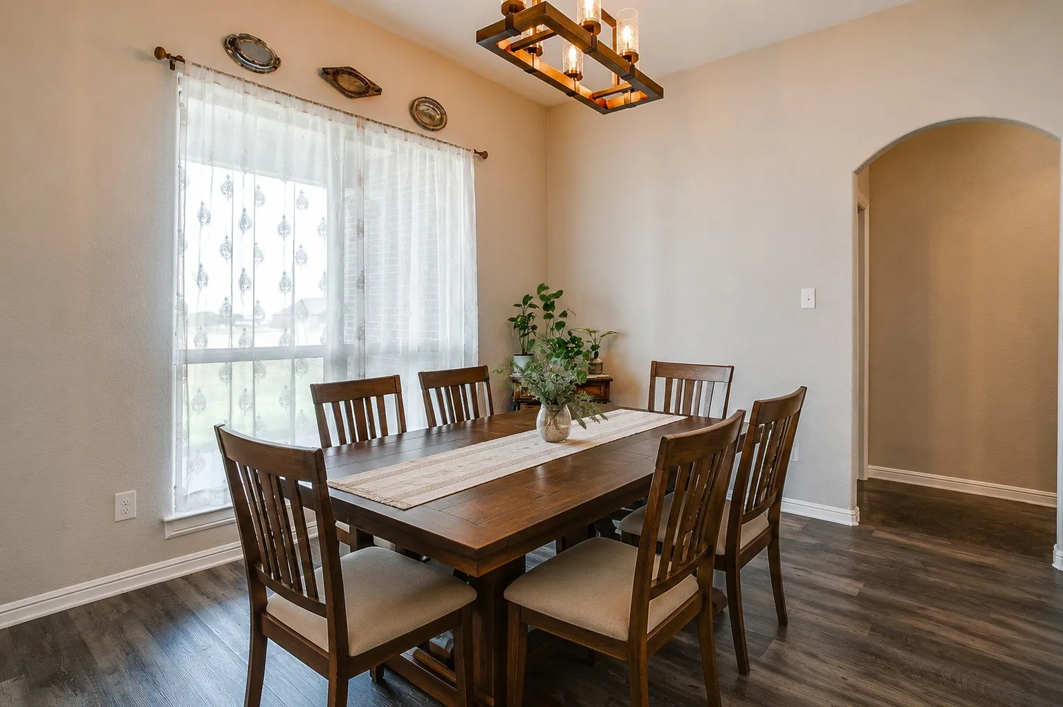 Window with sheer drapery, wood-finish flooring, recessed lighting, and an arched doorway - Virtually staged with AI
