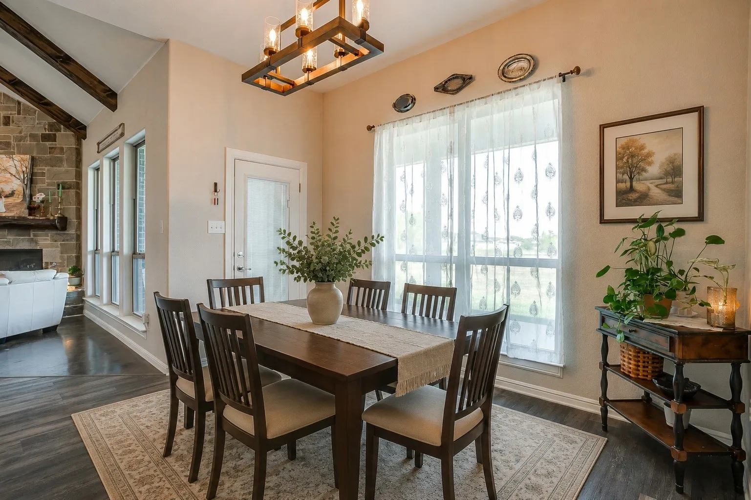 Vaulted ceiling with exposed wood beams, stone-faced fireplace, wood-finish flooring, and a multi-pane window - Virtually staged with AI