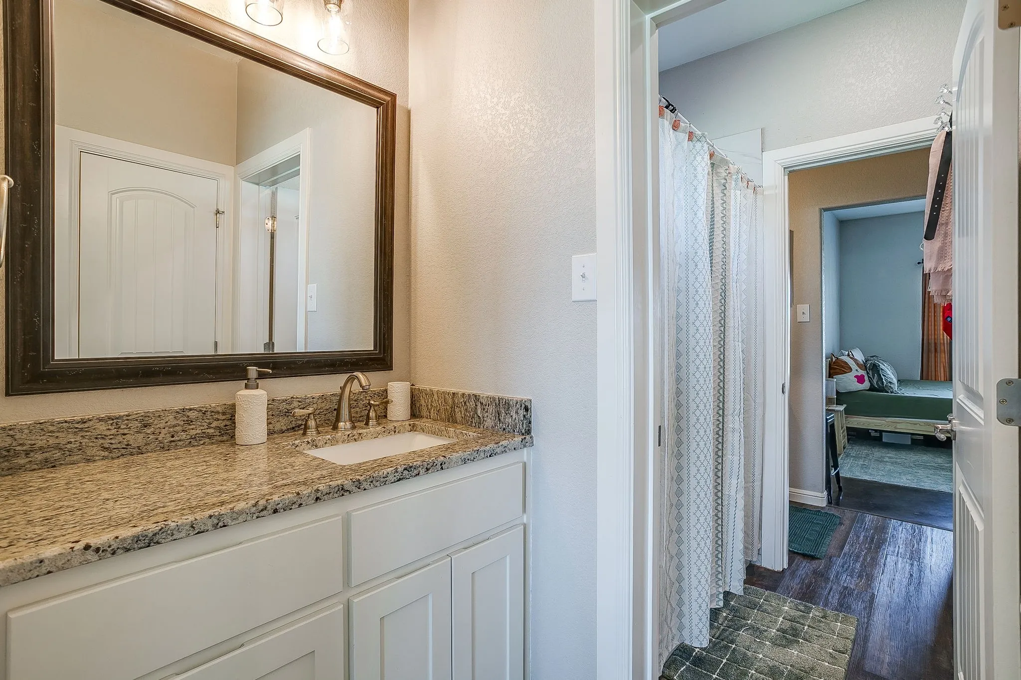 Vanity with a granite countertop, undermount sink, and brushed nickel faucet