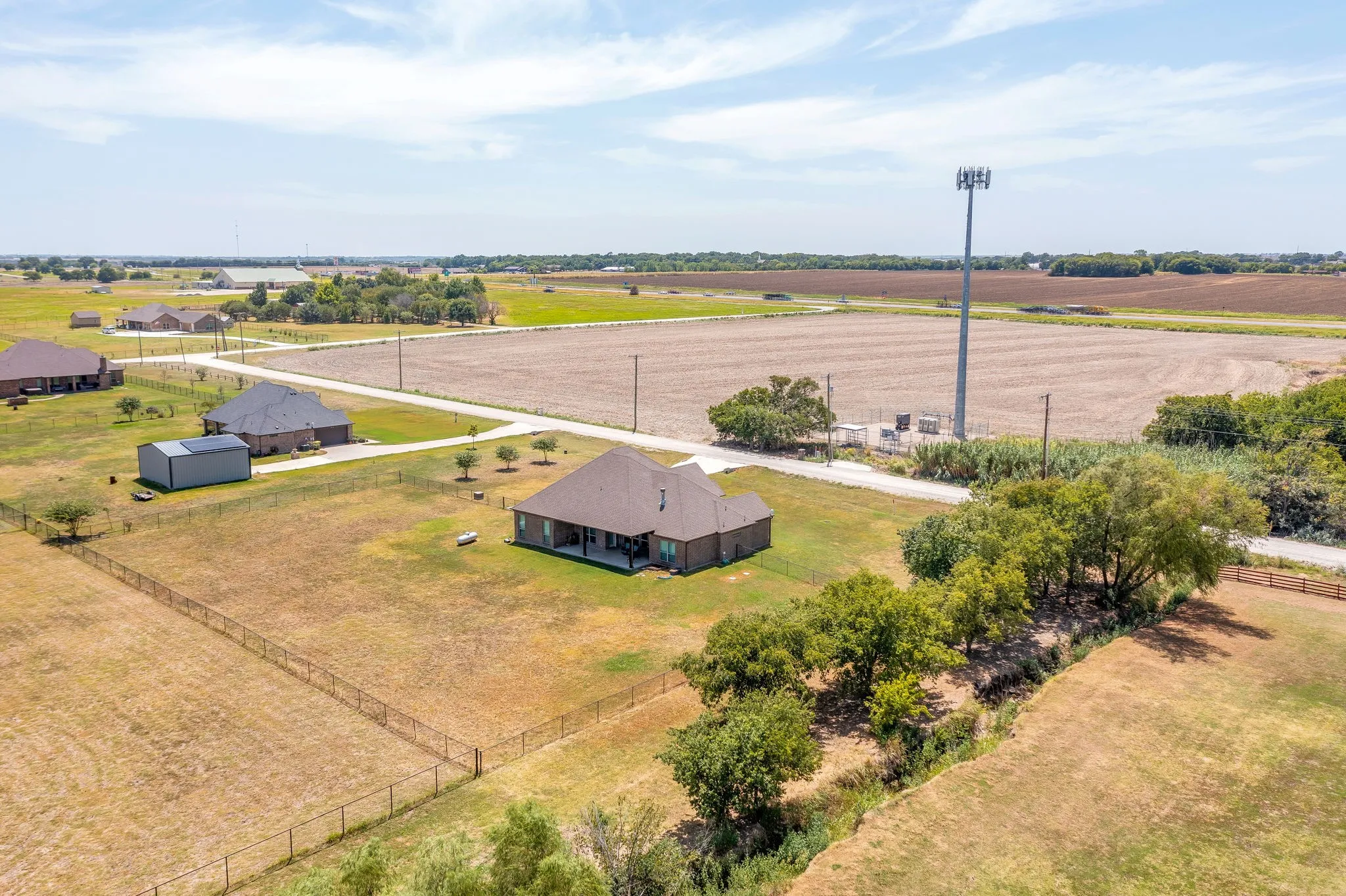 Spacious property featuring a single-story residence, a detached storage shed, and a fenced perimeter