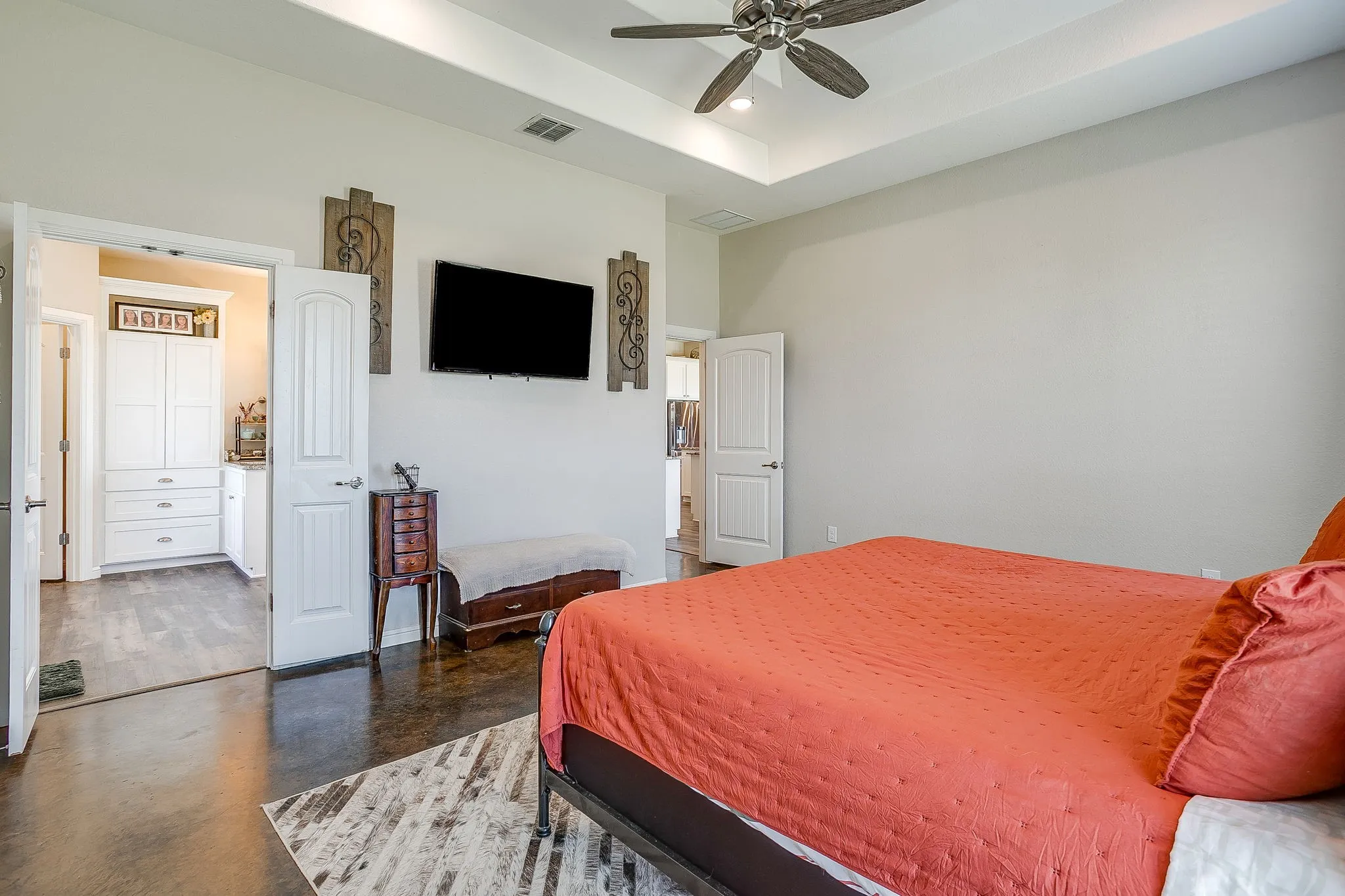Tray ceiling with recessed lighting, ceiling fan, and dark wood-finish flooring
