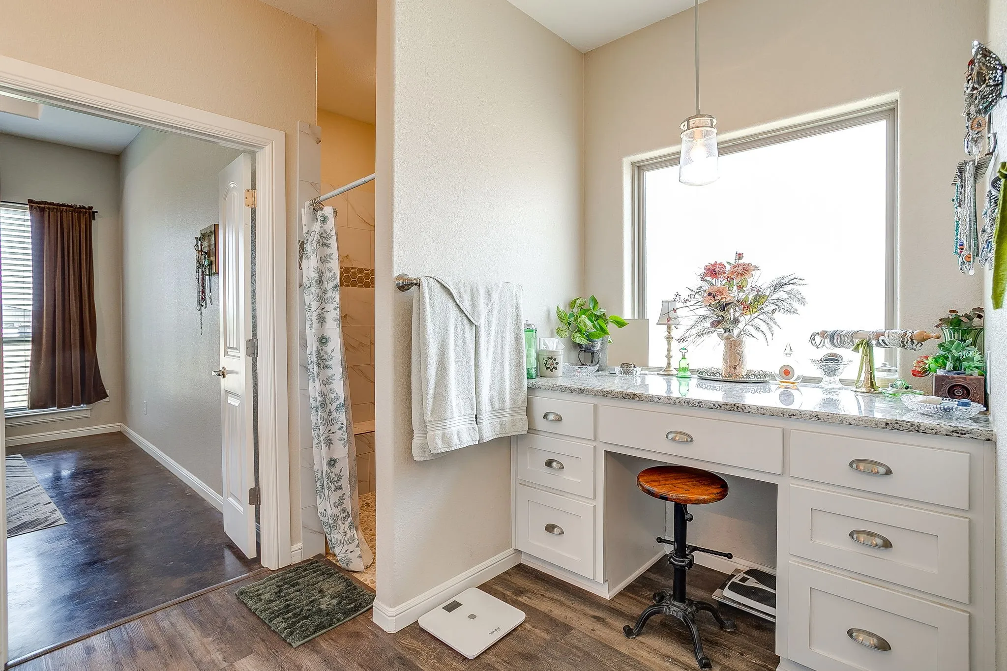 Built-in vanity with a speckled countertop, integrated cabinetry, and an overhead pendant light