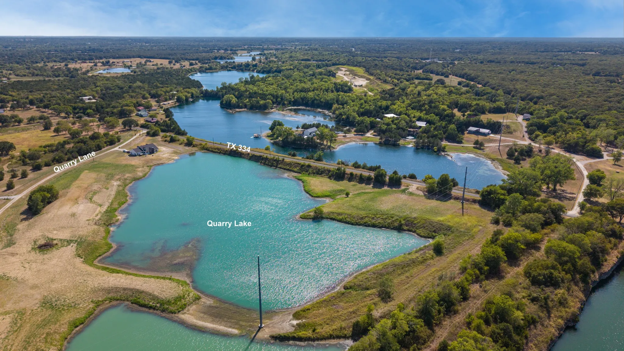 Expansive lakefront property featuring multiple bodies of water, diverse tree coverage, and direct access to Quarry Lake