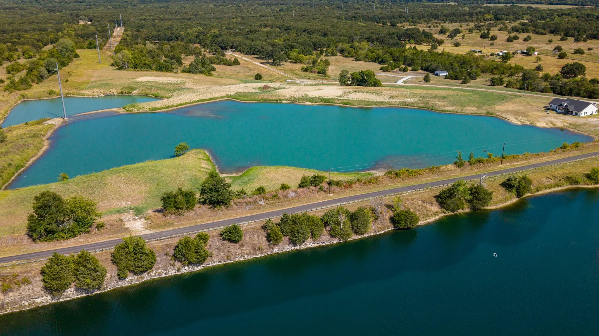 Expansive property featuring multiple bodies of water, surrounding undeveloped land, and dense tree coverage