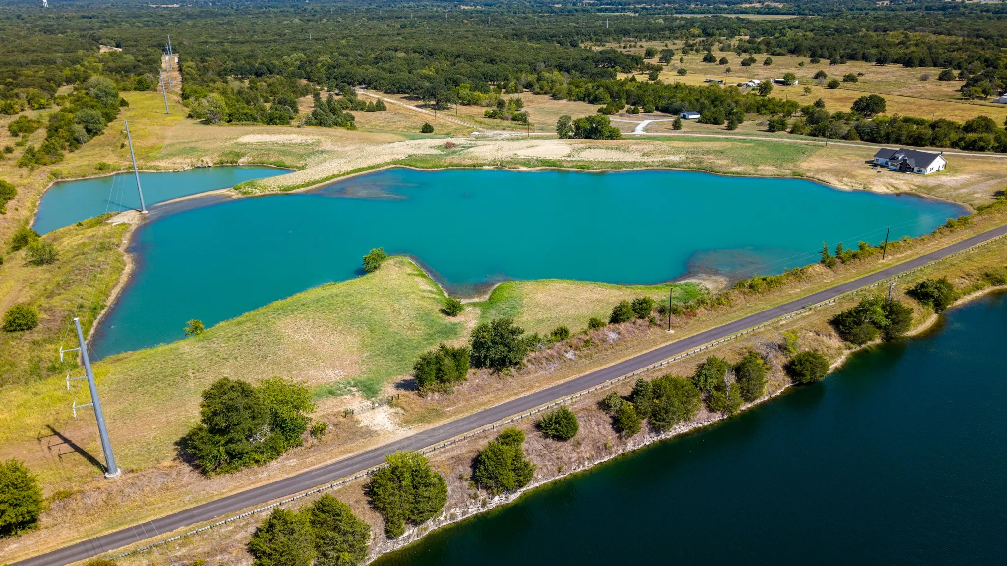 Expansive property featuring multiple bodies of water, extensive natural landscape, and a two-story residence