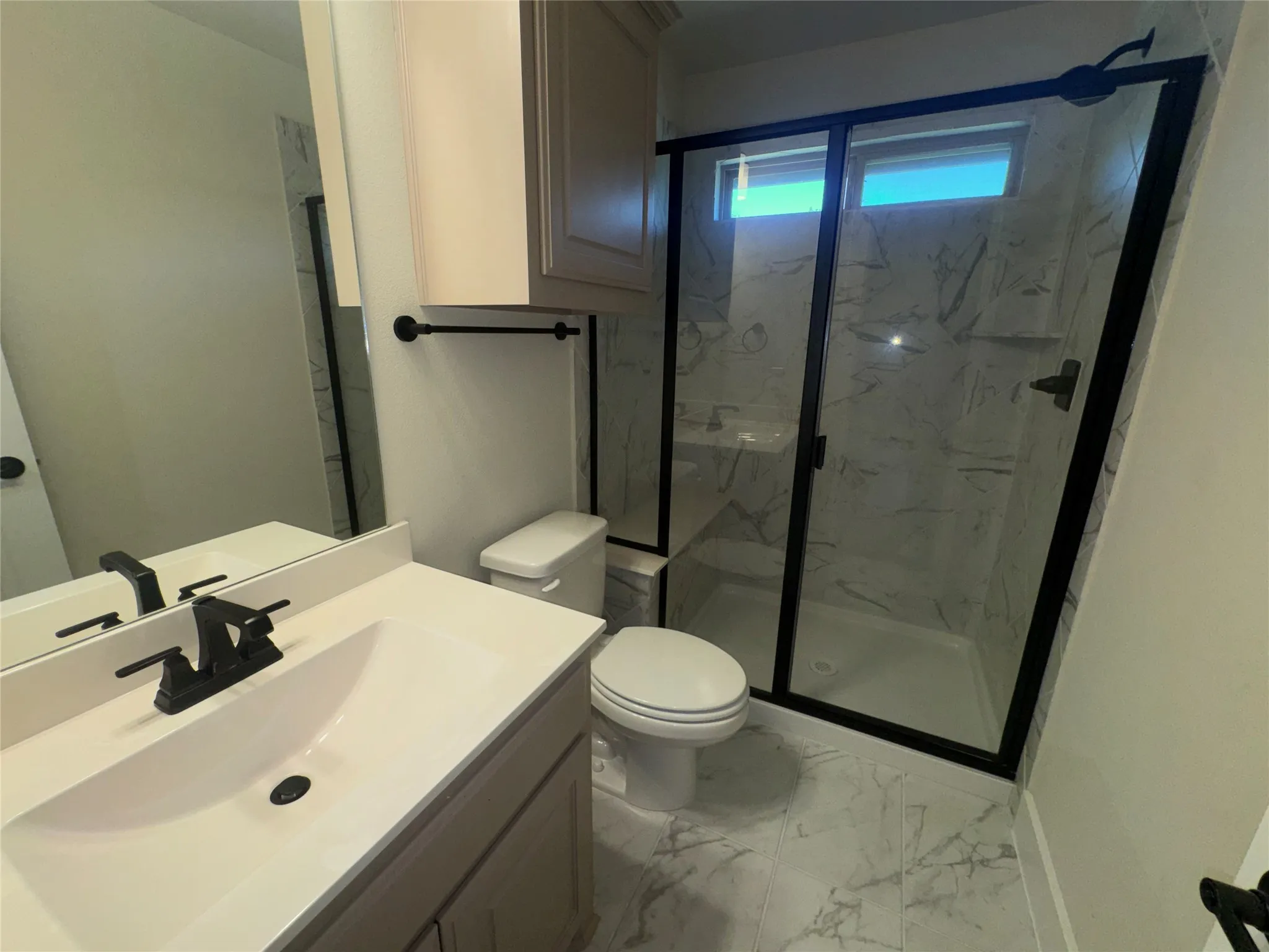 Walk-in shower with black-framed glass enclosure