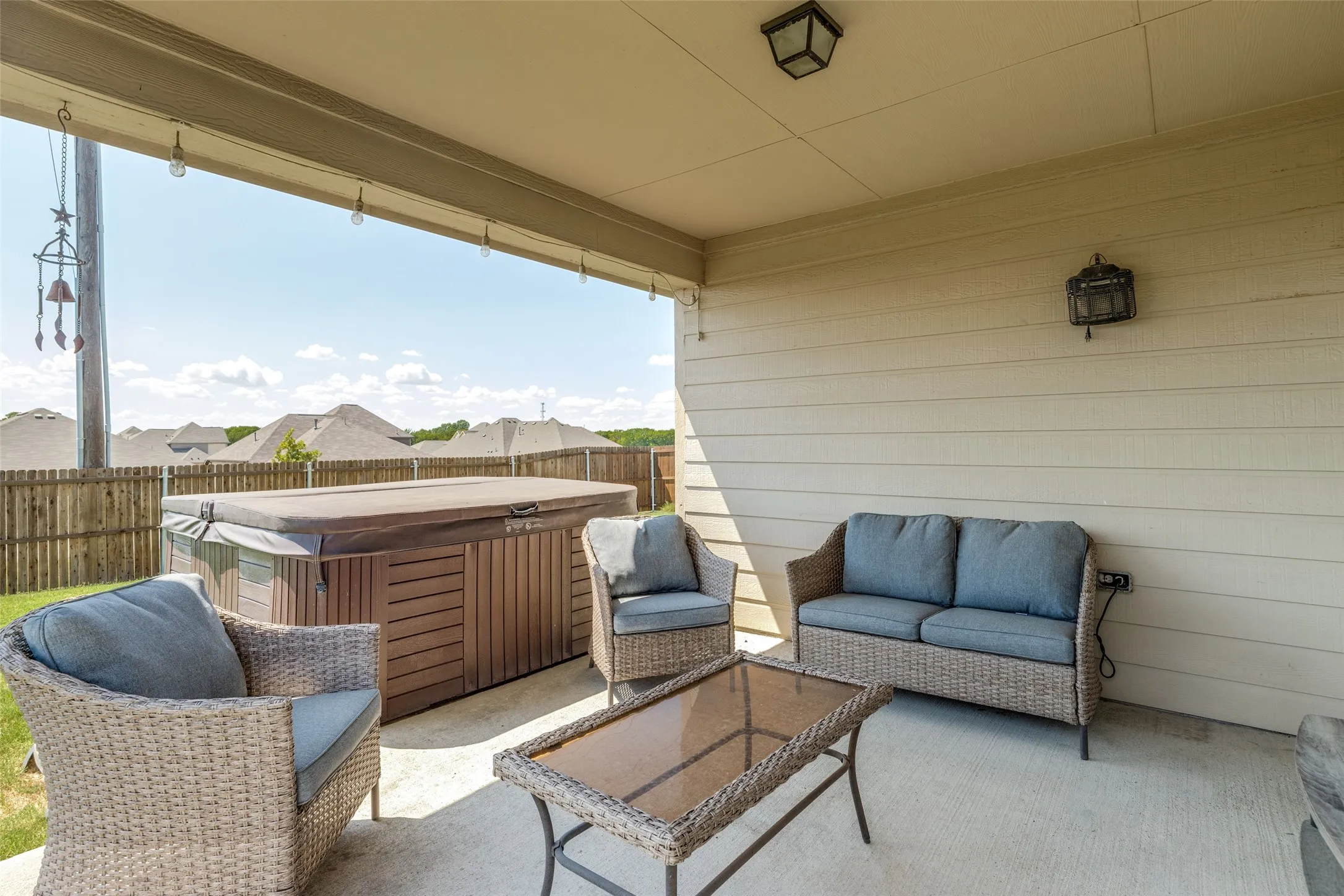 Covered concrete patio with overhead lighting including spa.