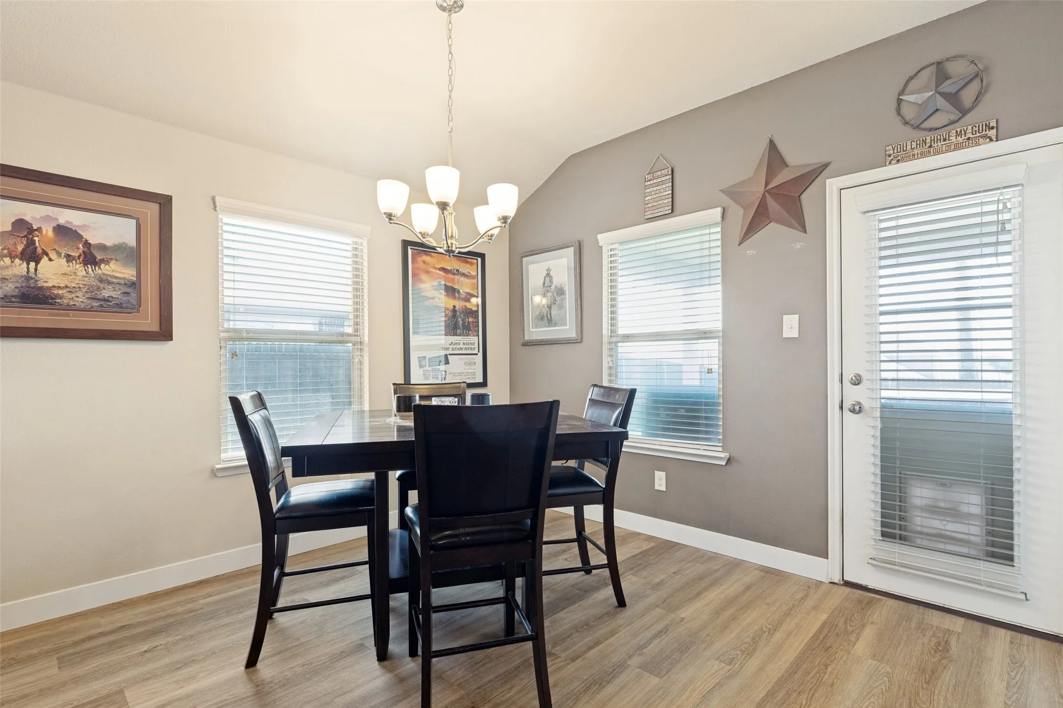 Vaulted ceiling, wood-finish flooring, two windows with blinds, recessed lighting, and a partial light fixture