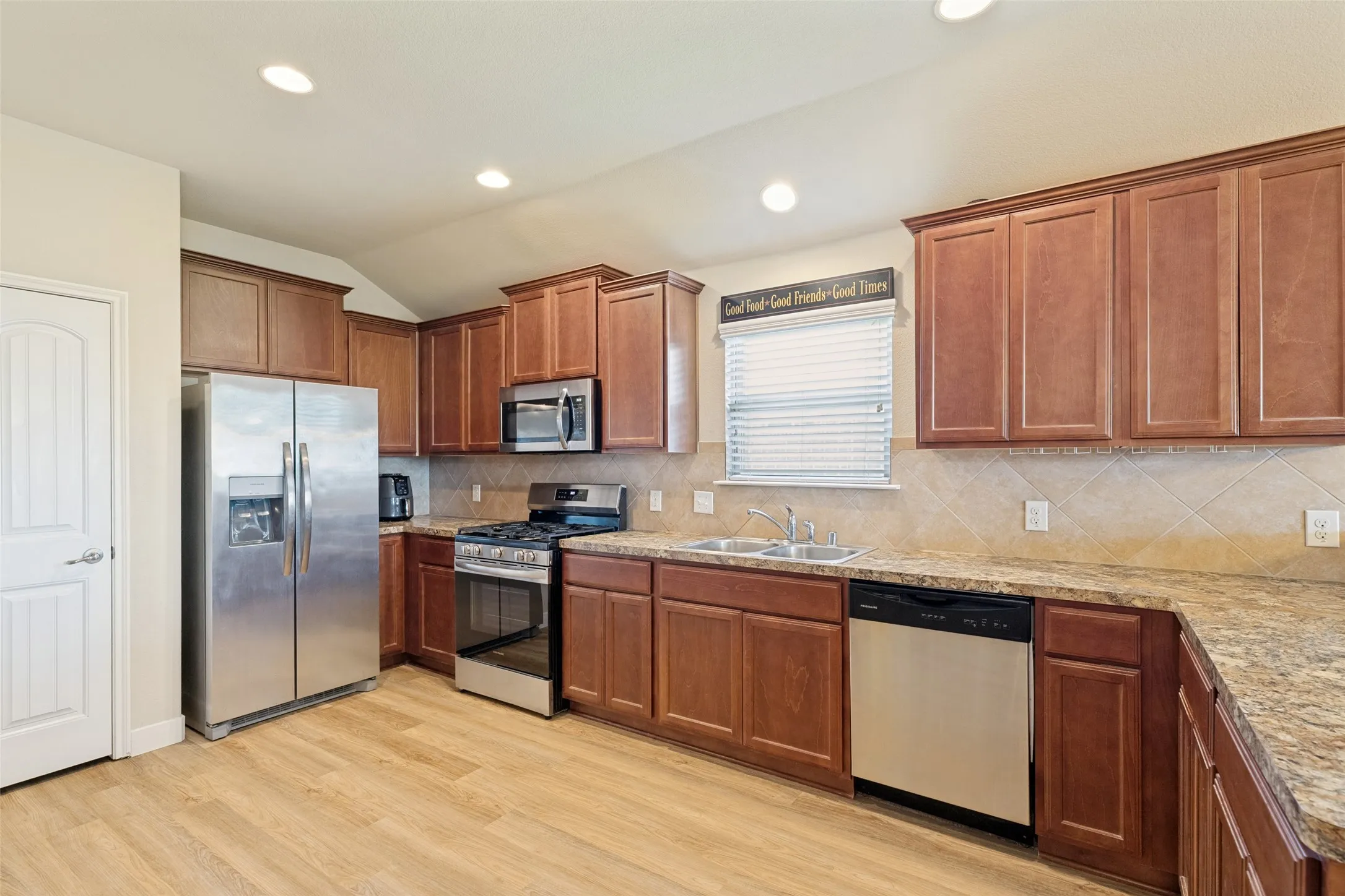 Kitchen featuring wood-finish flooring, wood cabinetry, stainless steel appliances, and recessed lighting