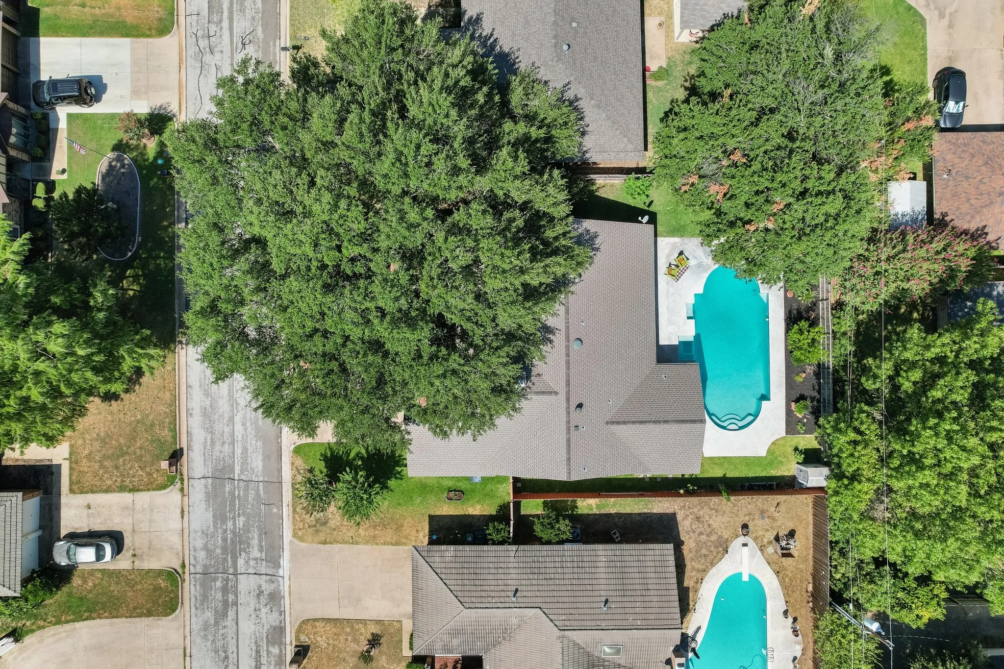 The aerial view puts it all into perspective, showcasing the home's footprint, mature tree canopy, backyard space, and impressive in-ground pool.